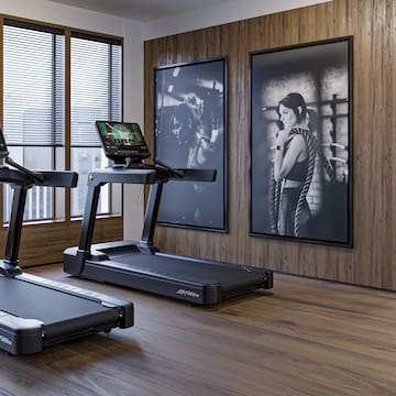a room with treadmills and a couple of pictures on the wall