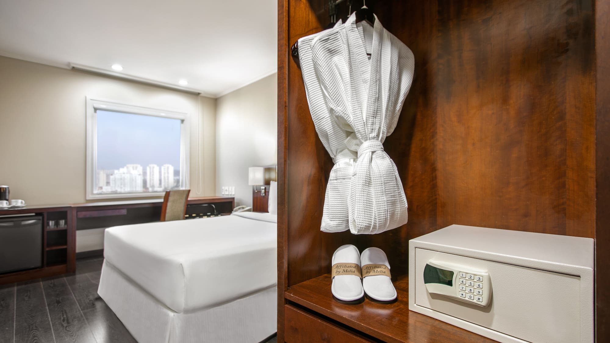 a white robe and slippers on a shelf in a hotel room