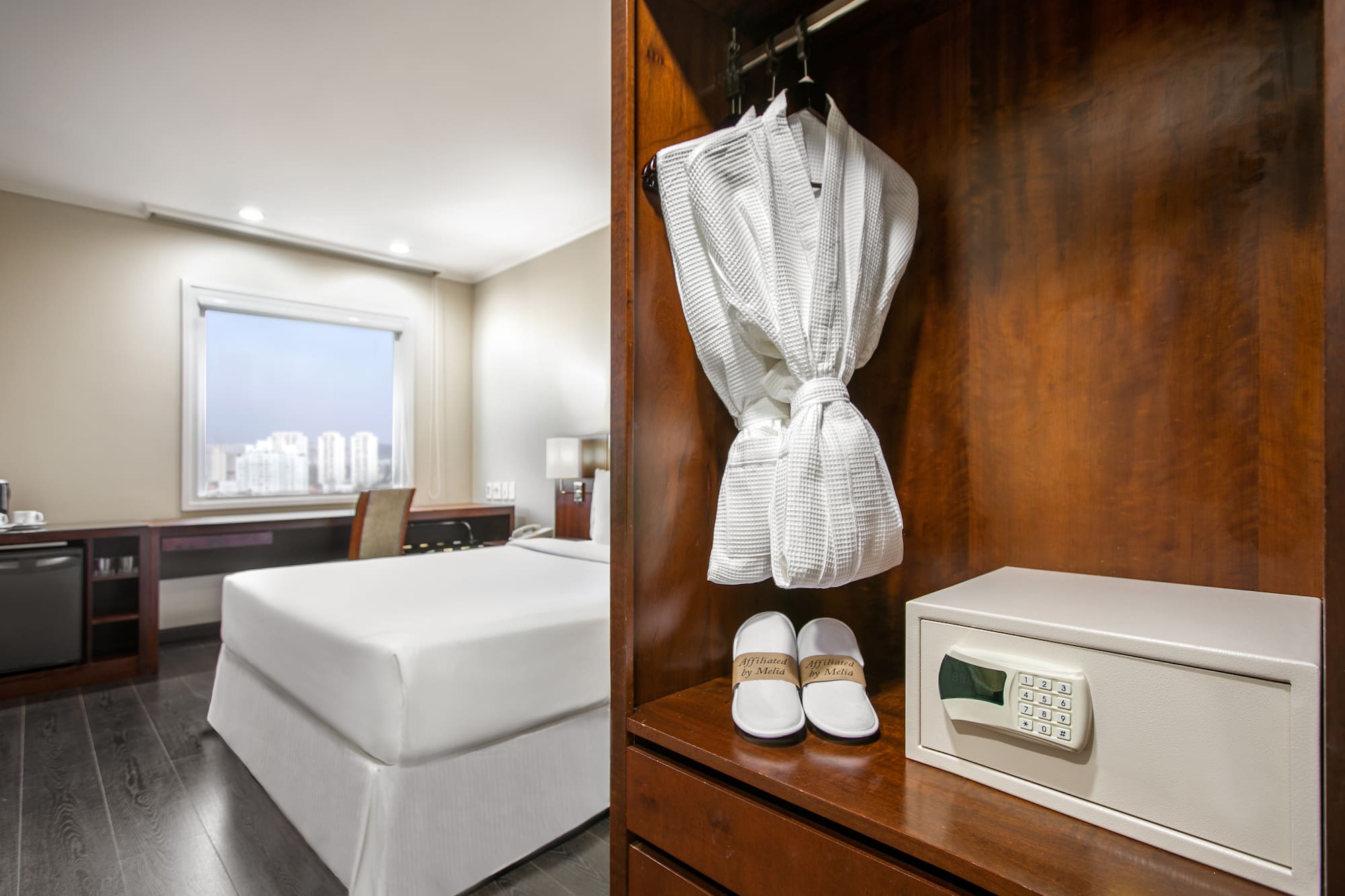 a white robe and slippers on a shelf in a hotel room