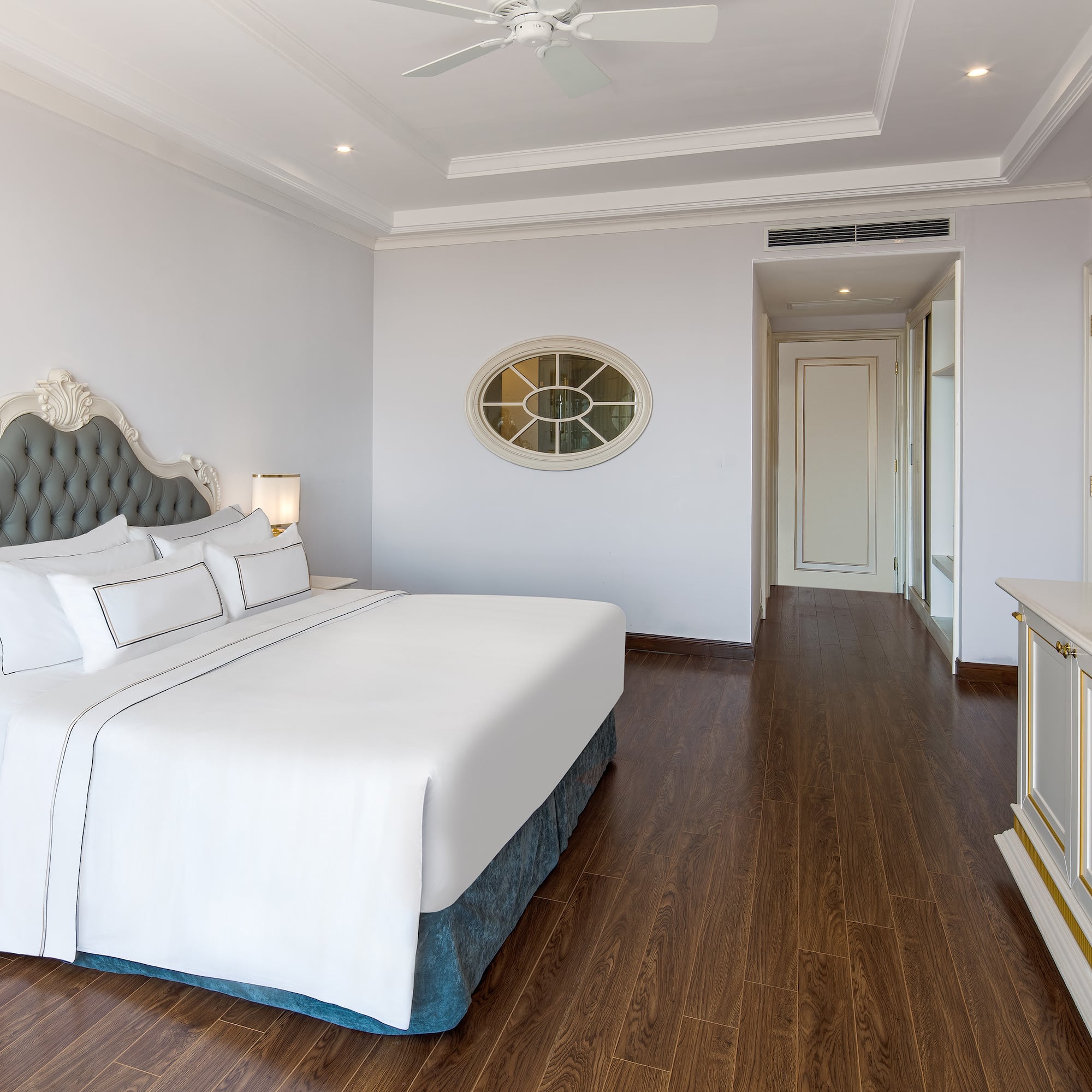 a bedroom with a white bed and wood floor