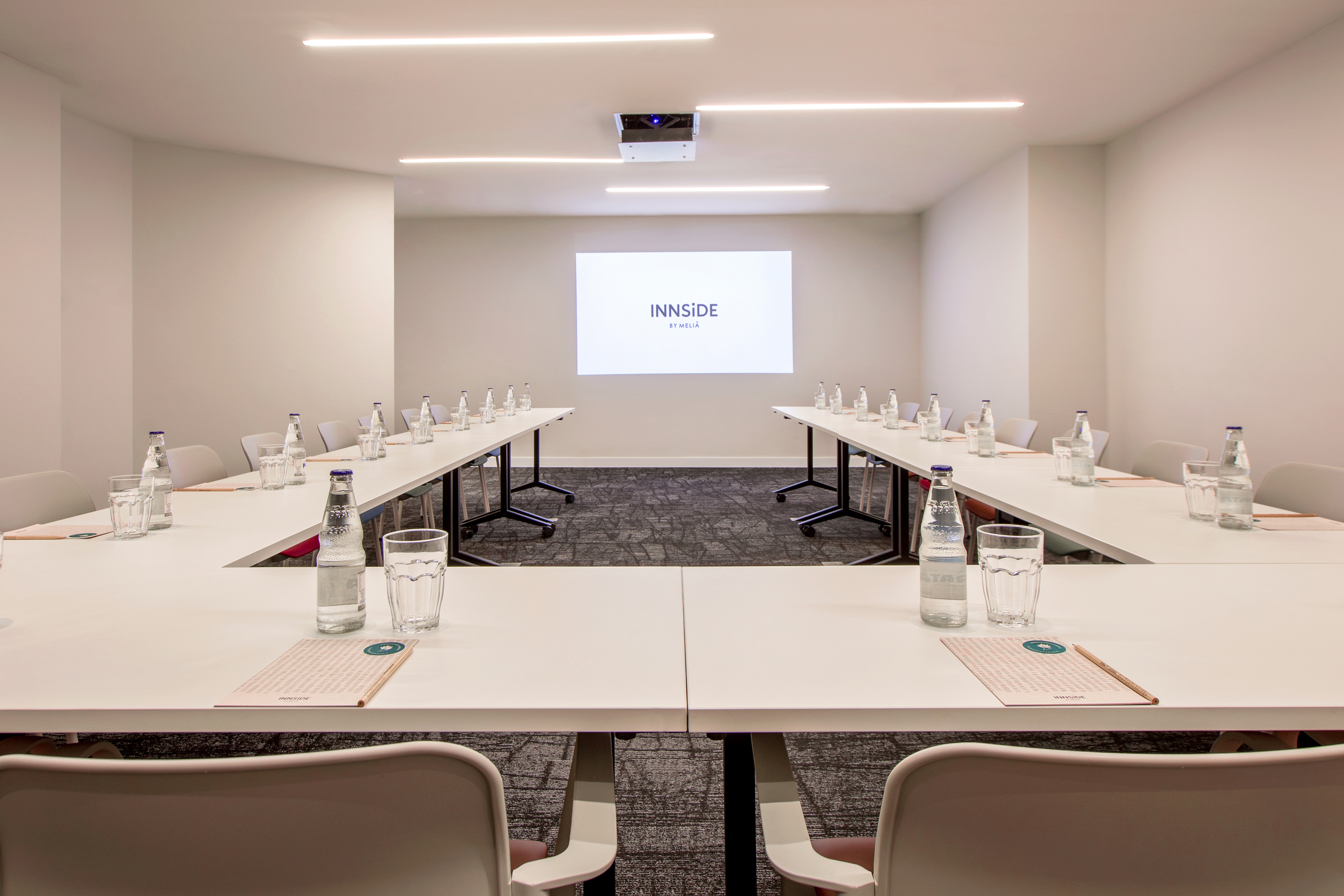 a room with tables and chairs and a projector screen