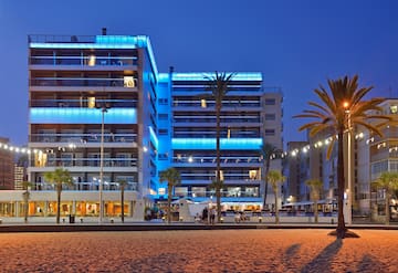 a building with palm trees and people on the beach