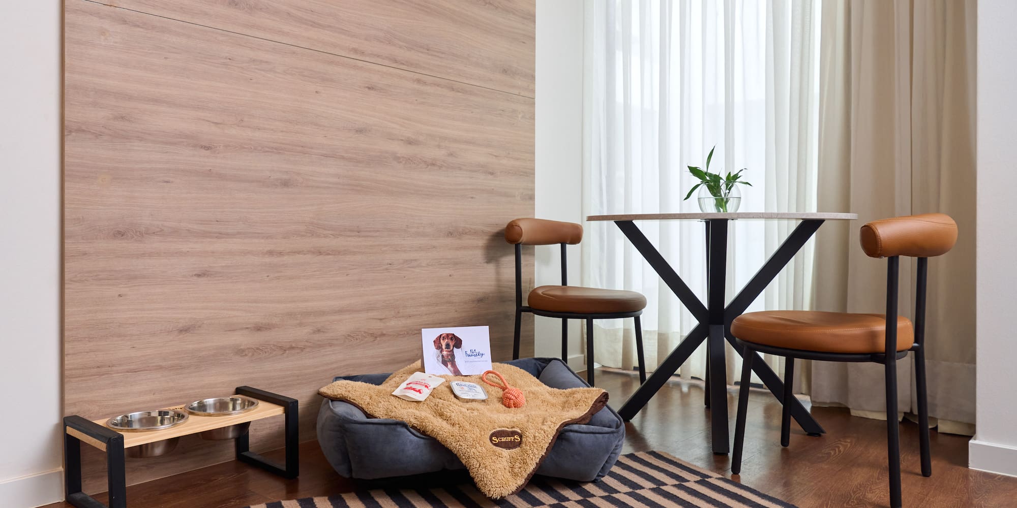 a dog bed with food and a dog bowl on a rug in a room