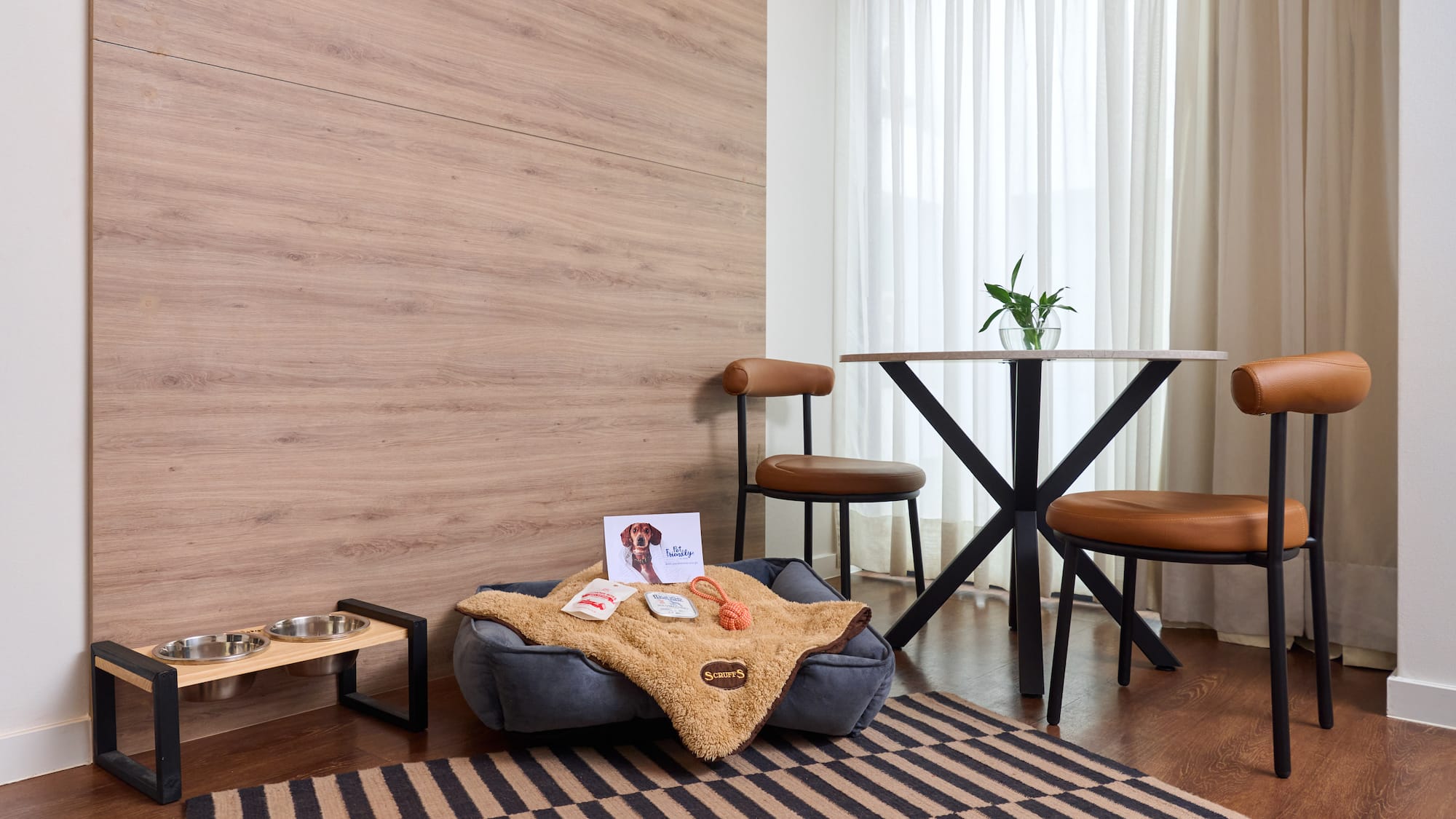 a dog bed with food and a dog bowl on a rug in a room
