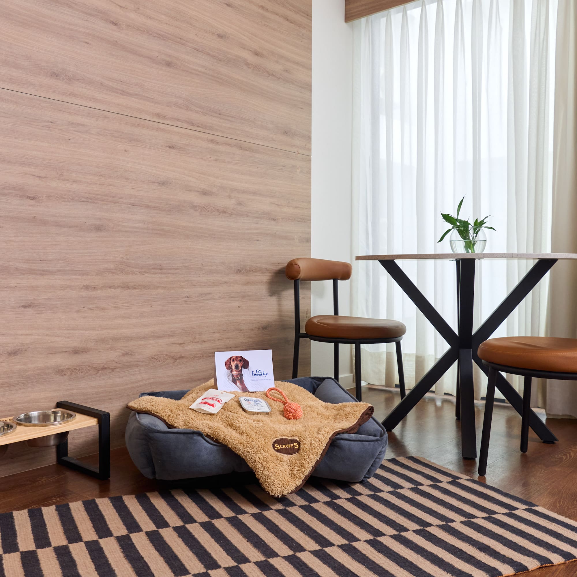 a dog bed with food and a dog bowl on a rug in a room