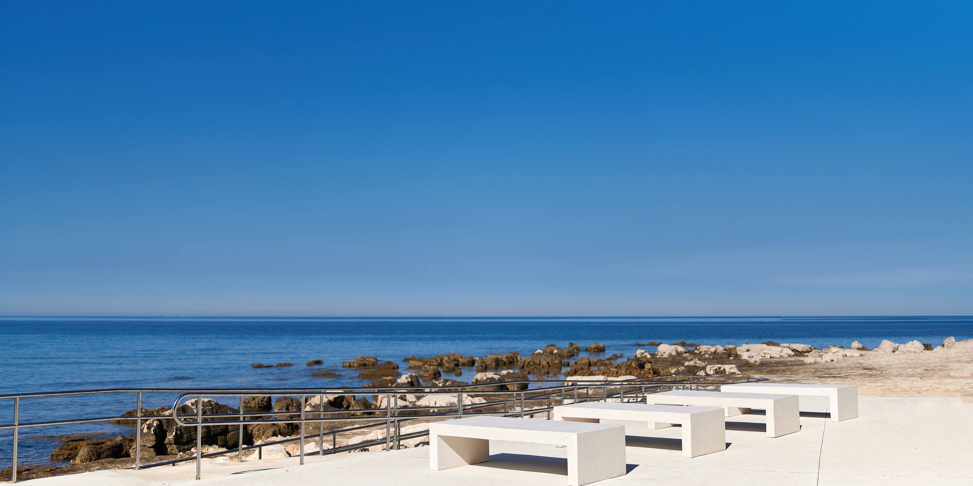 a white benches on a beach