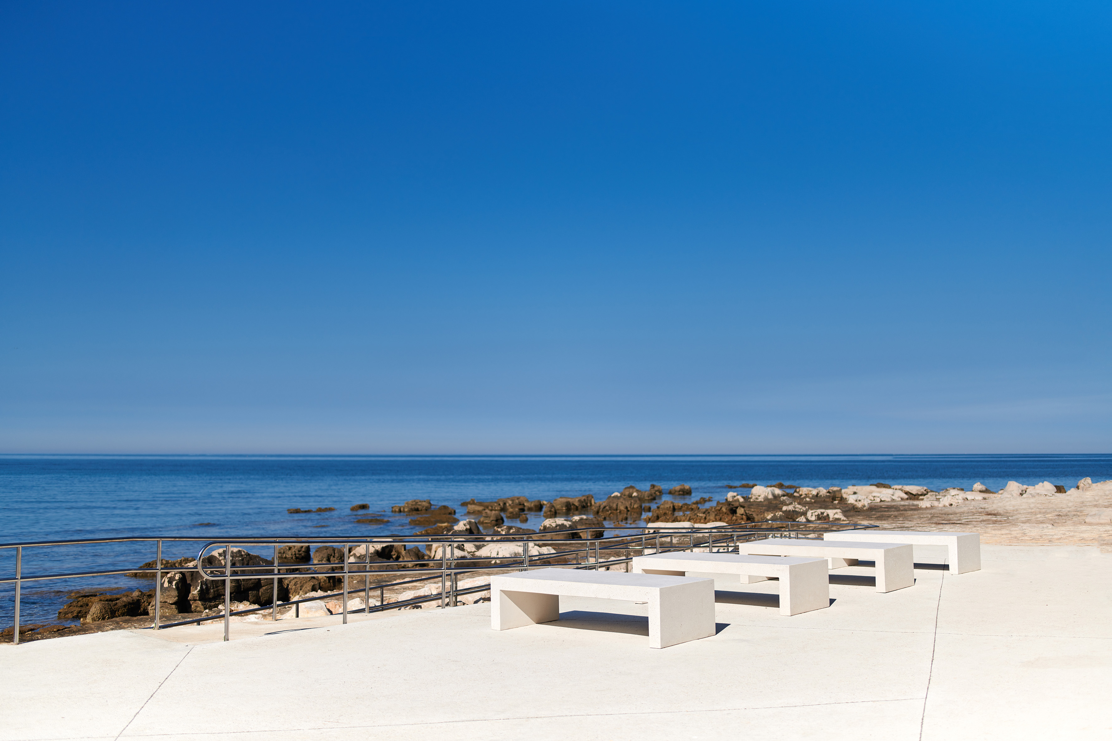 a white benches on a beach