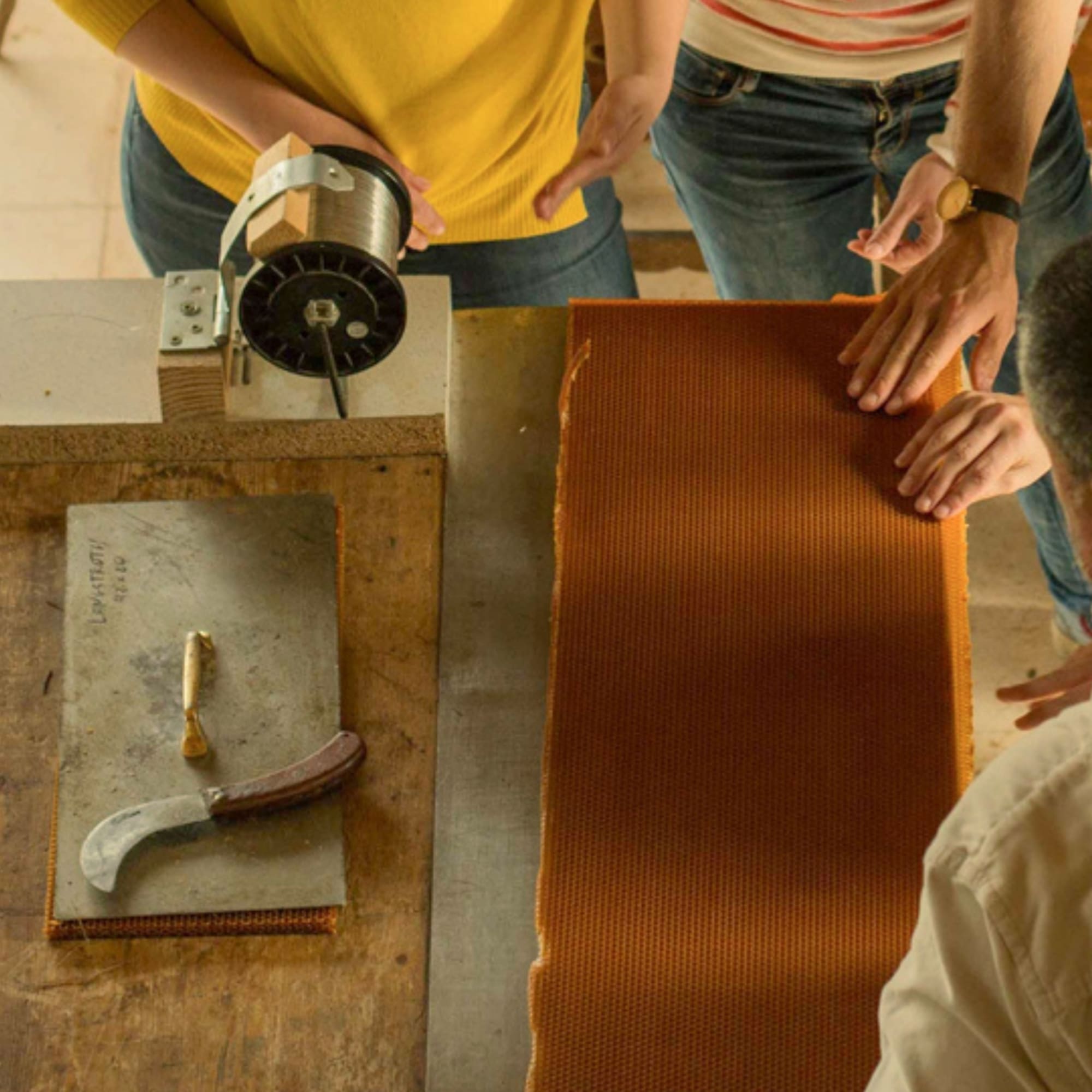 a group of people working on a piece of wood