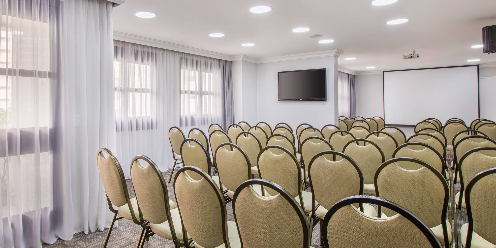 a room with many chairs and a screen