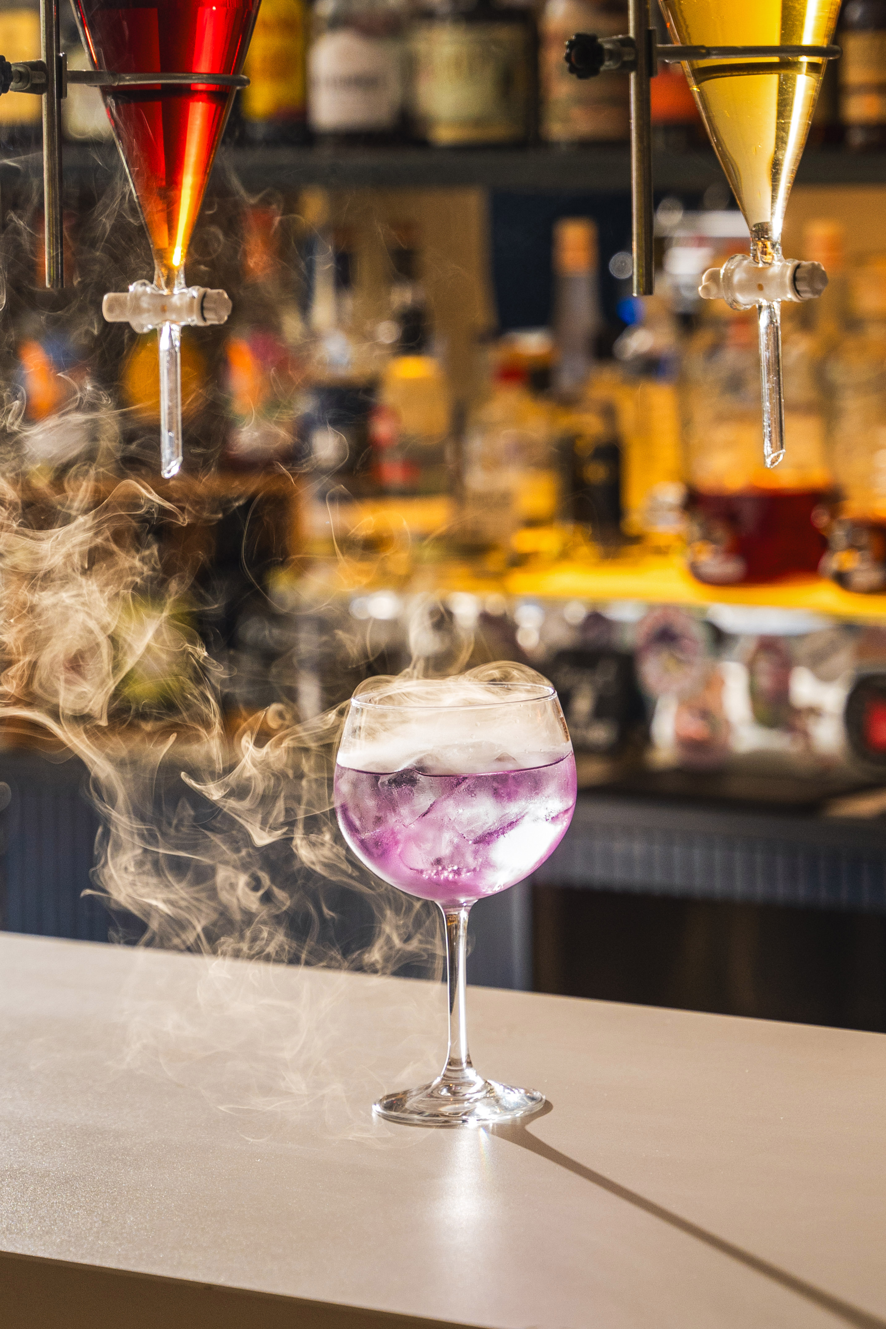 a glass with purple liquid and smoke coming out of it