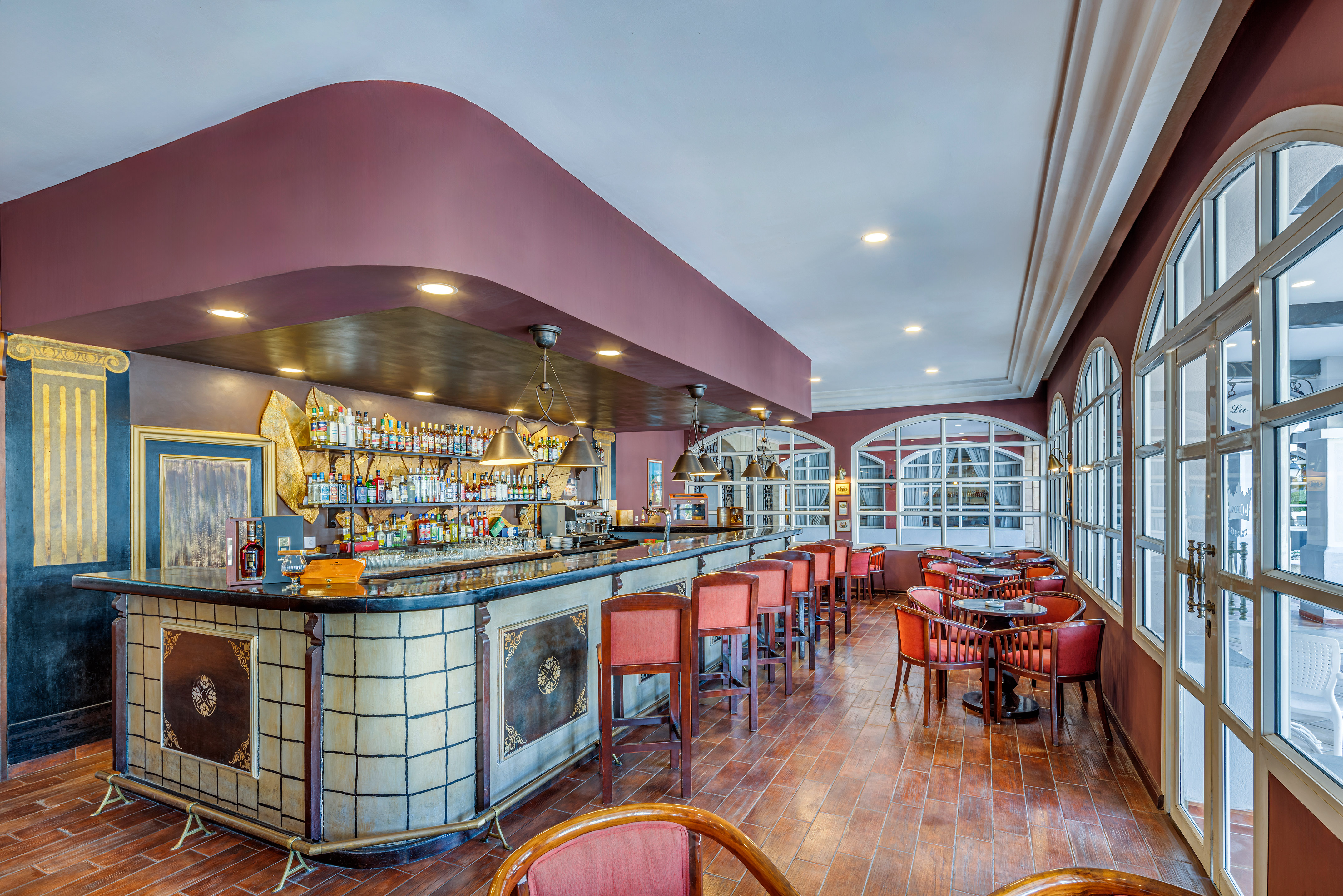 a bar with chairs and tables in a room