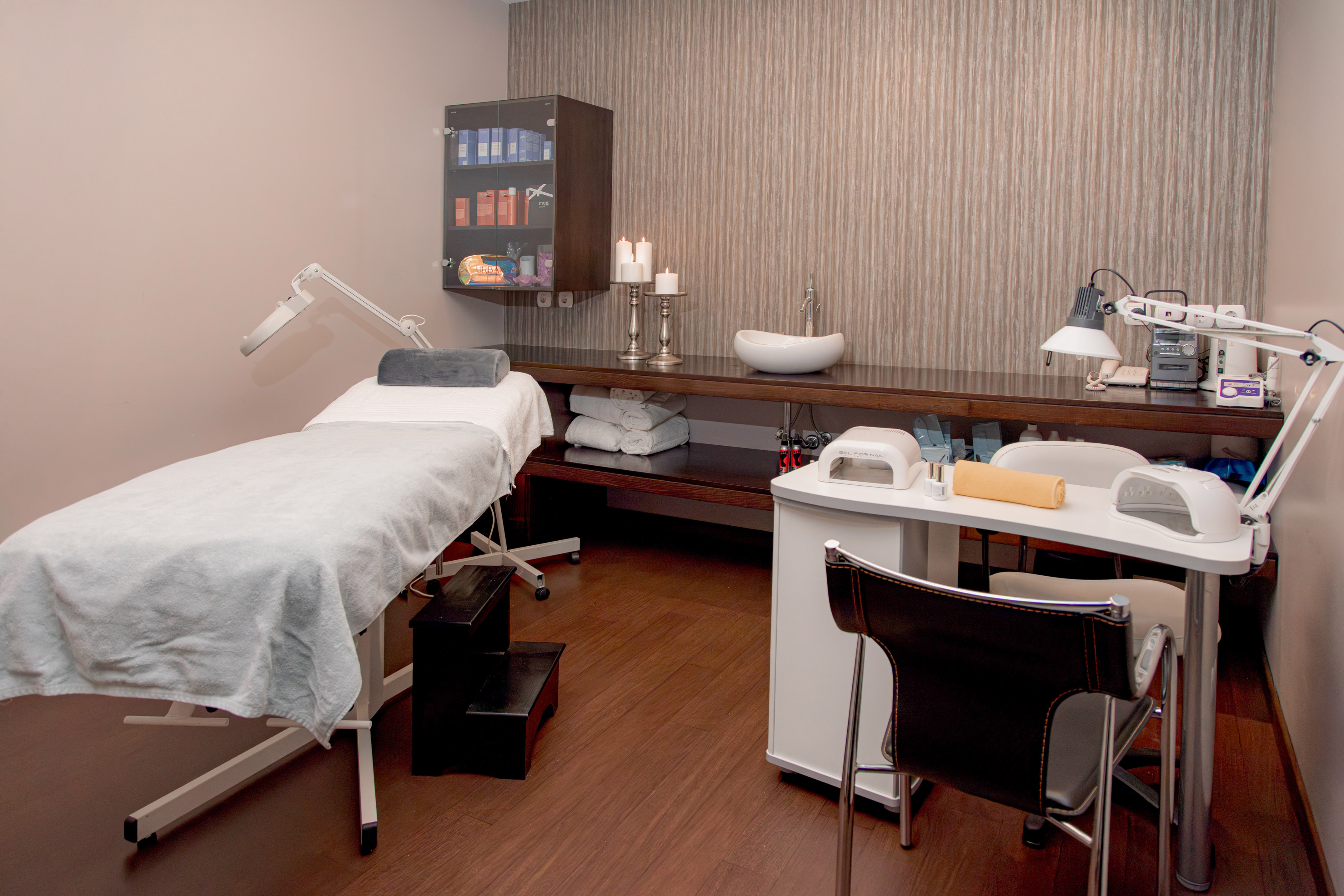 Beauty spa room with treatment bed and manicure station.