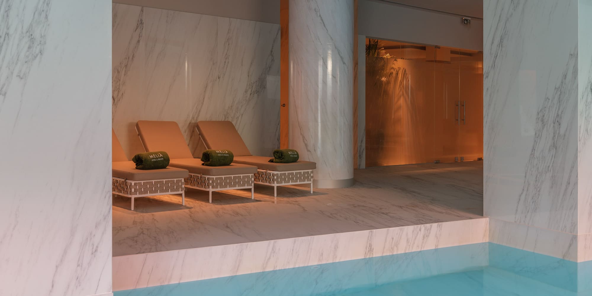 a pool with chairs and a large column