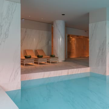 a pool with chairs and a large column