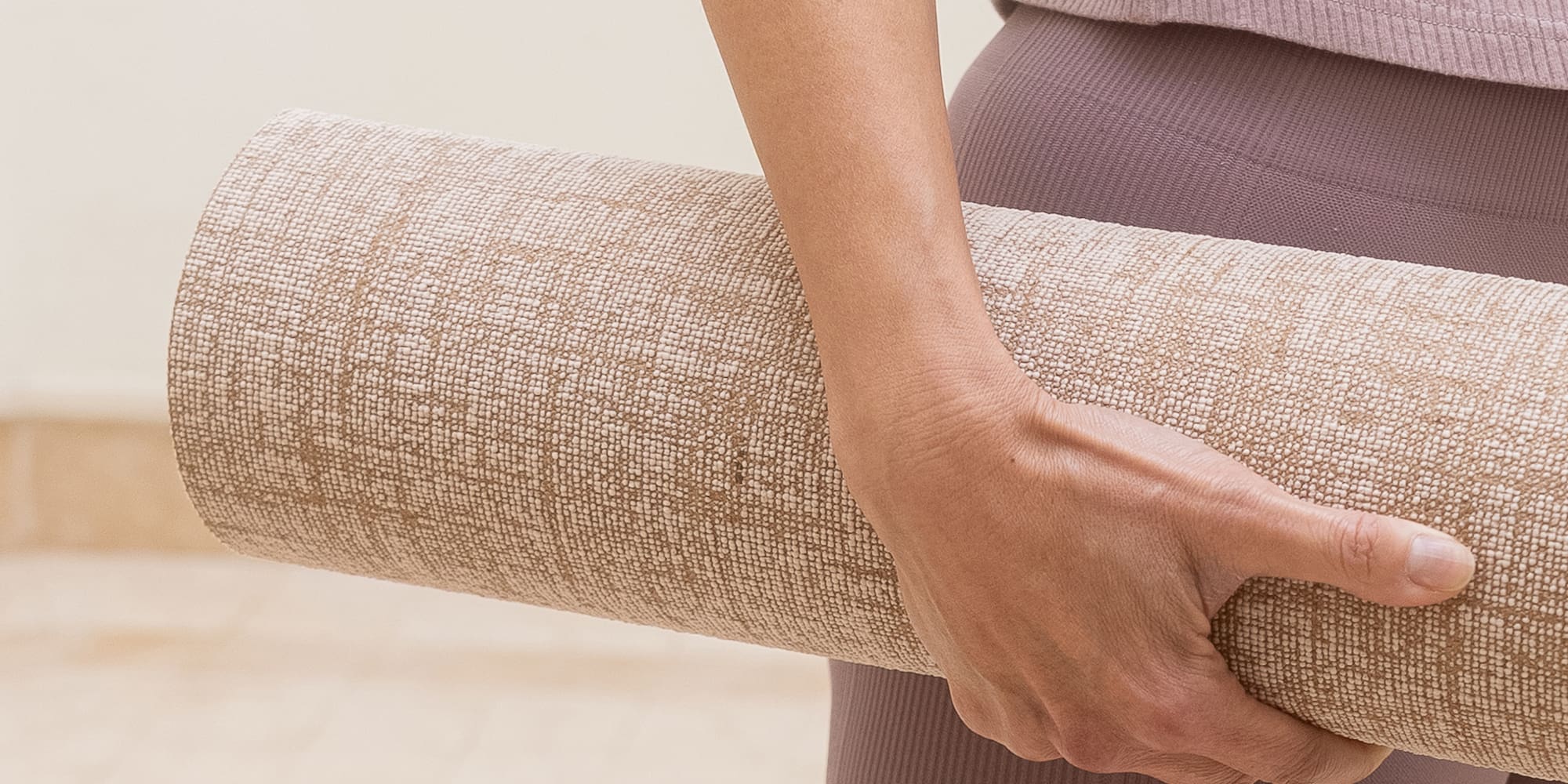 a person holding a rolled up yoga mat