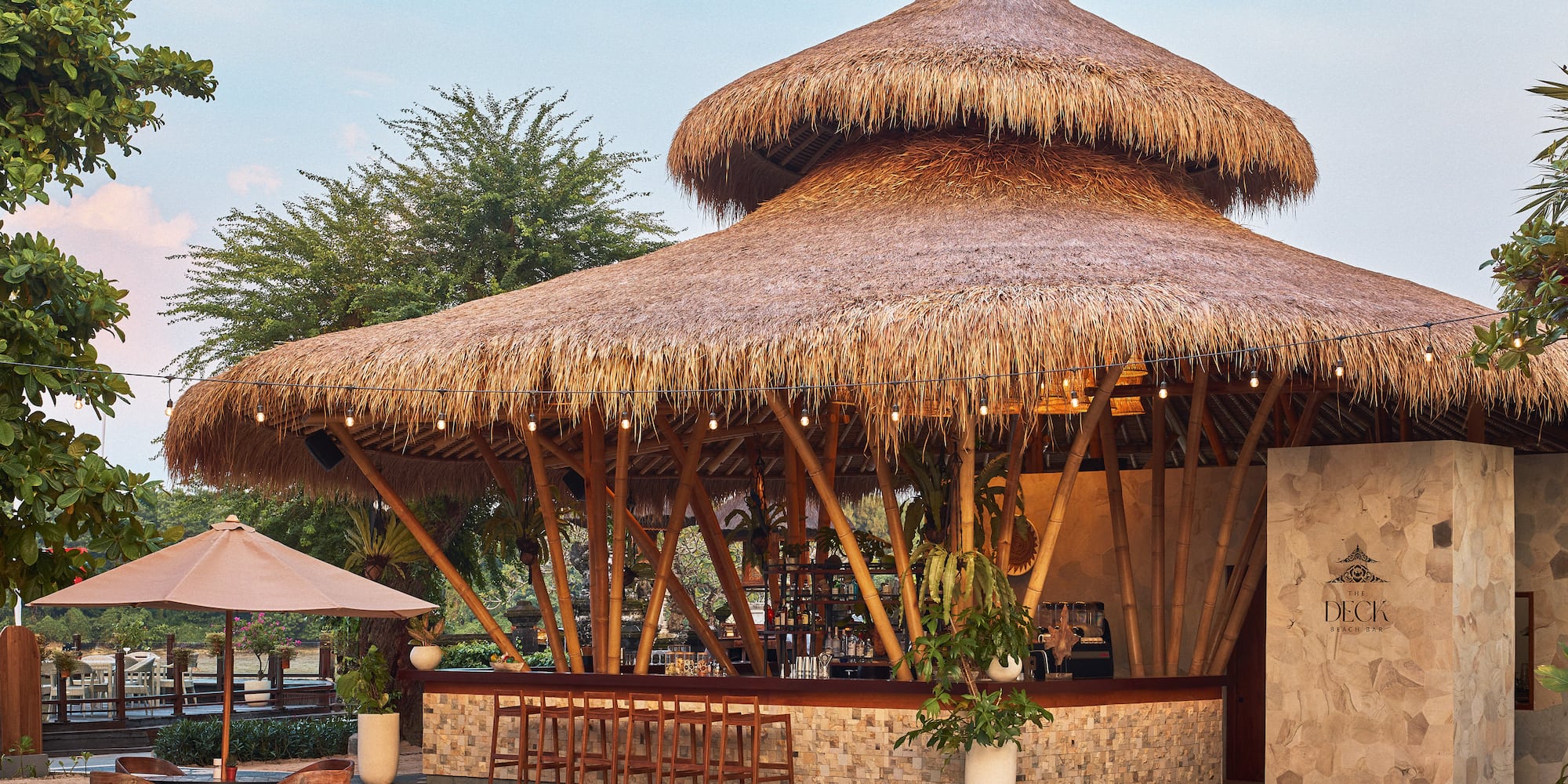 The Deck beach bar: thatched roof, bamboo structure, outdoor seating.