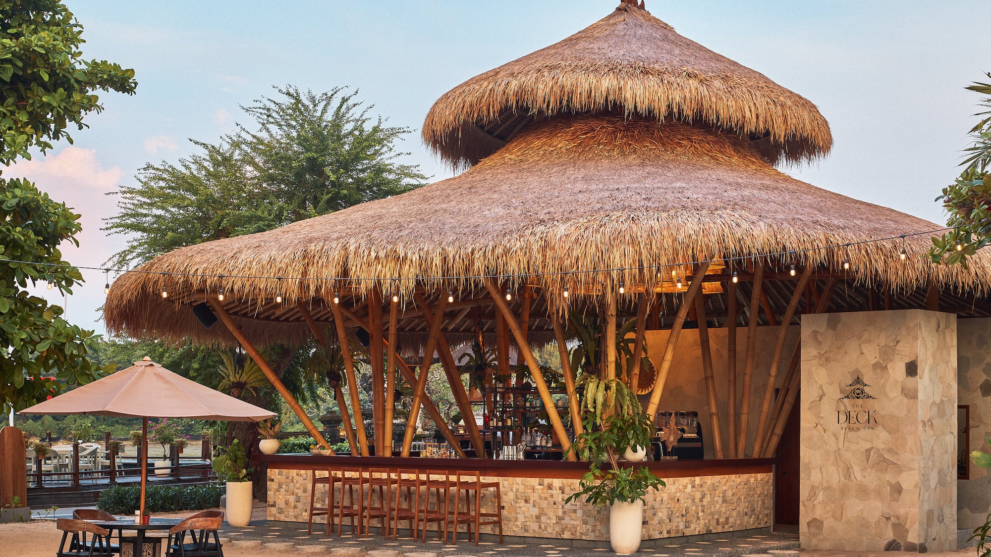 The Deck beach bar: thatched roof, bamboo structure, outdoor seating.
