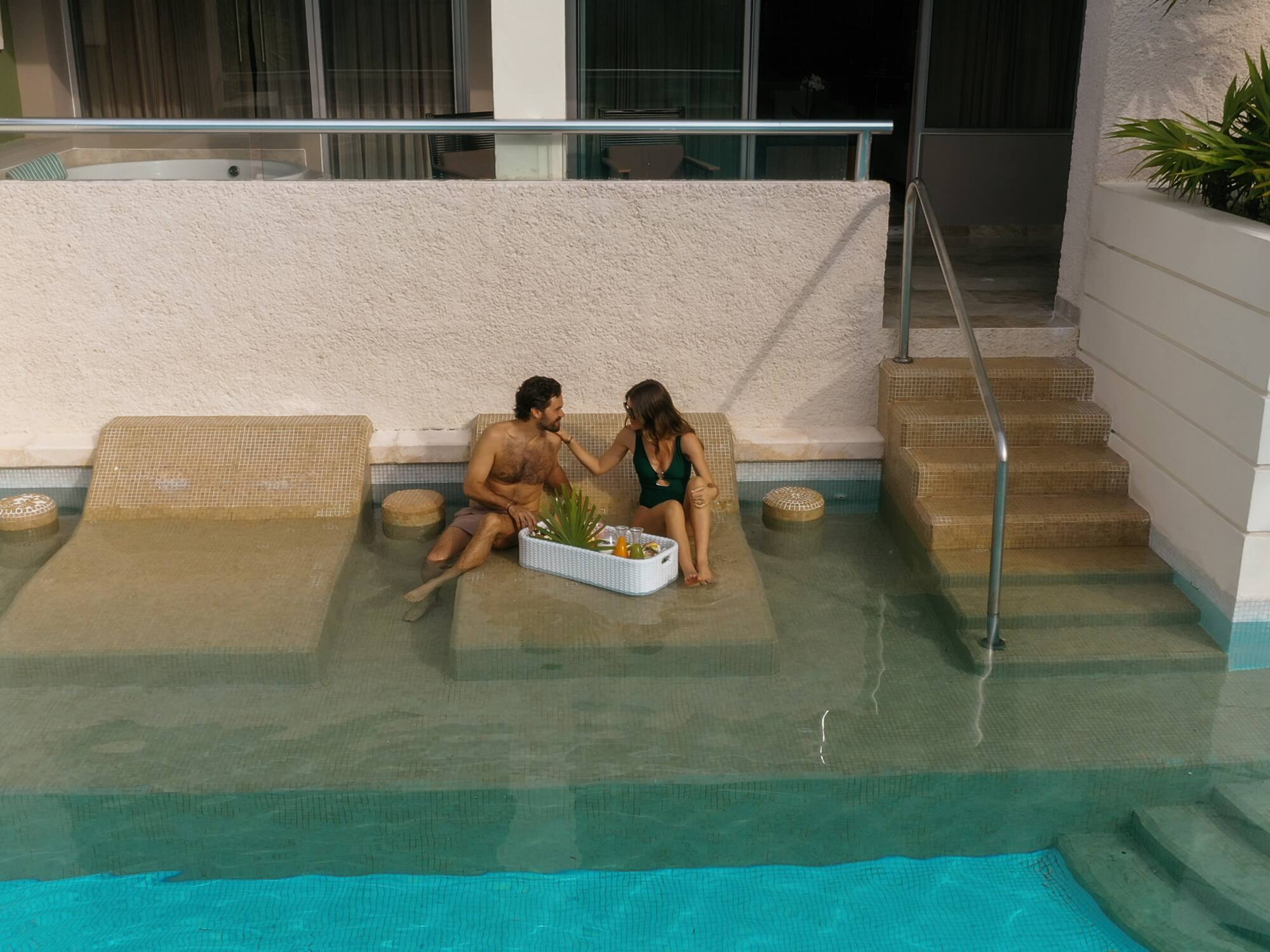 a man and woman sitting on a pool