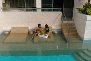 a man and woman sitting on a pool