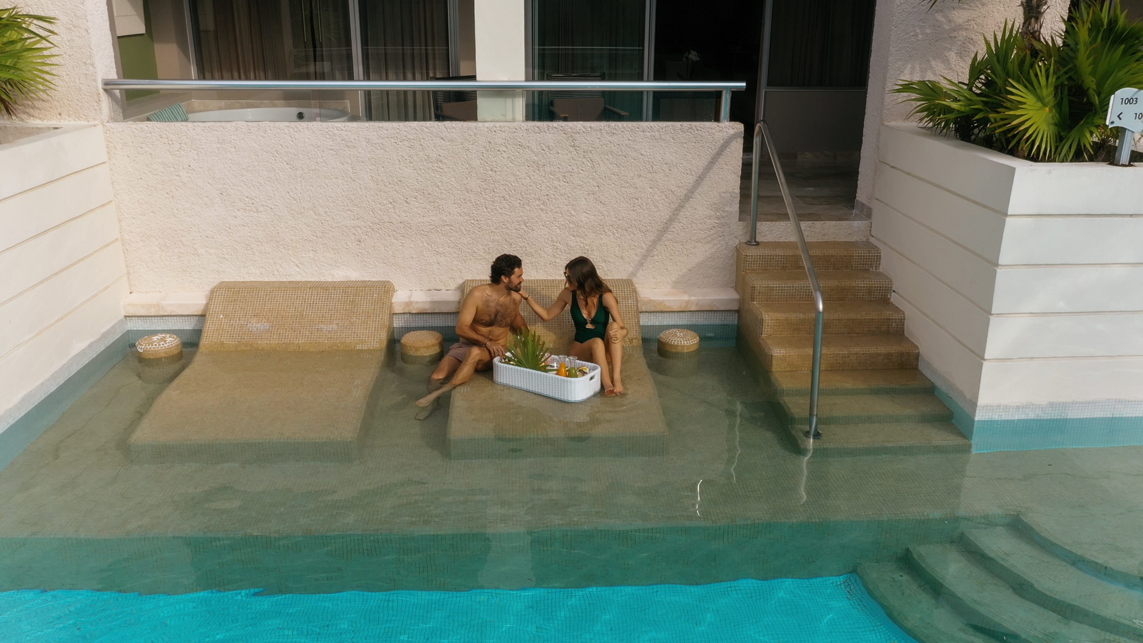 a man and woman sitting on a pool