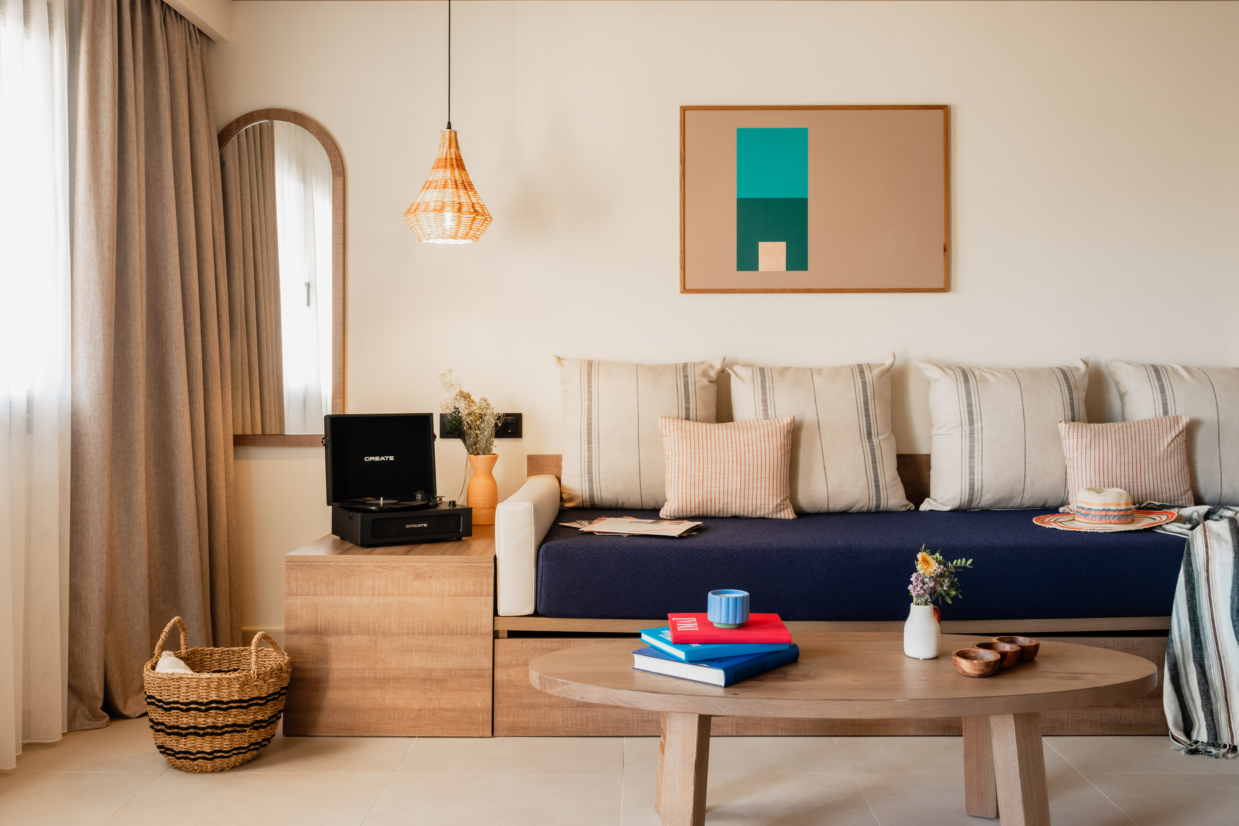 Living room with navy daybed, record player, wooden coffee table, and abstract art.