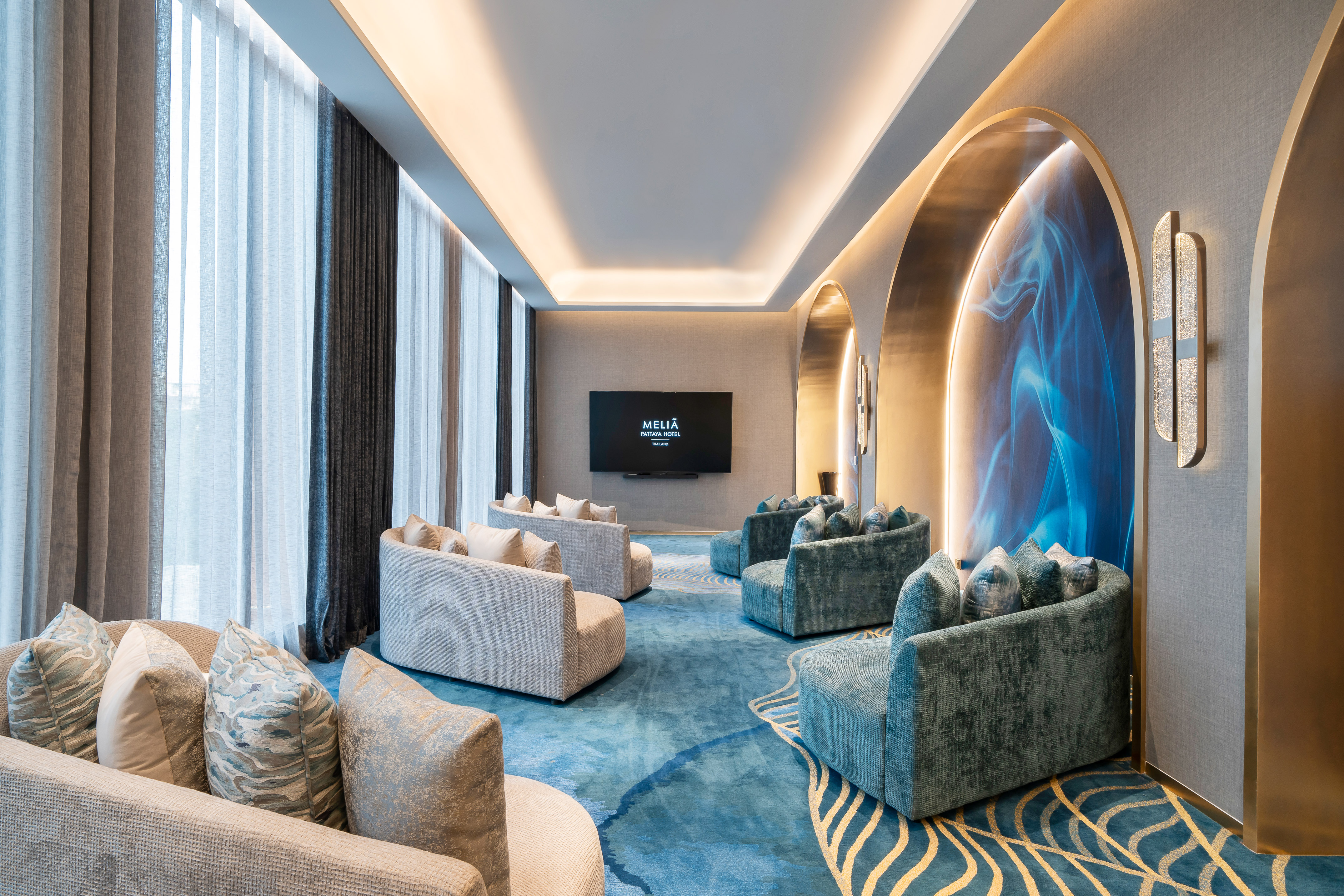 Meliã Pattaya Hotel lounge: modern sofas, blue patterned carpet, large TV. - Shad - Meliá Pattaya Hotel, Pattaya