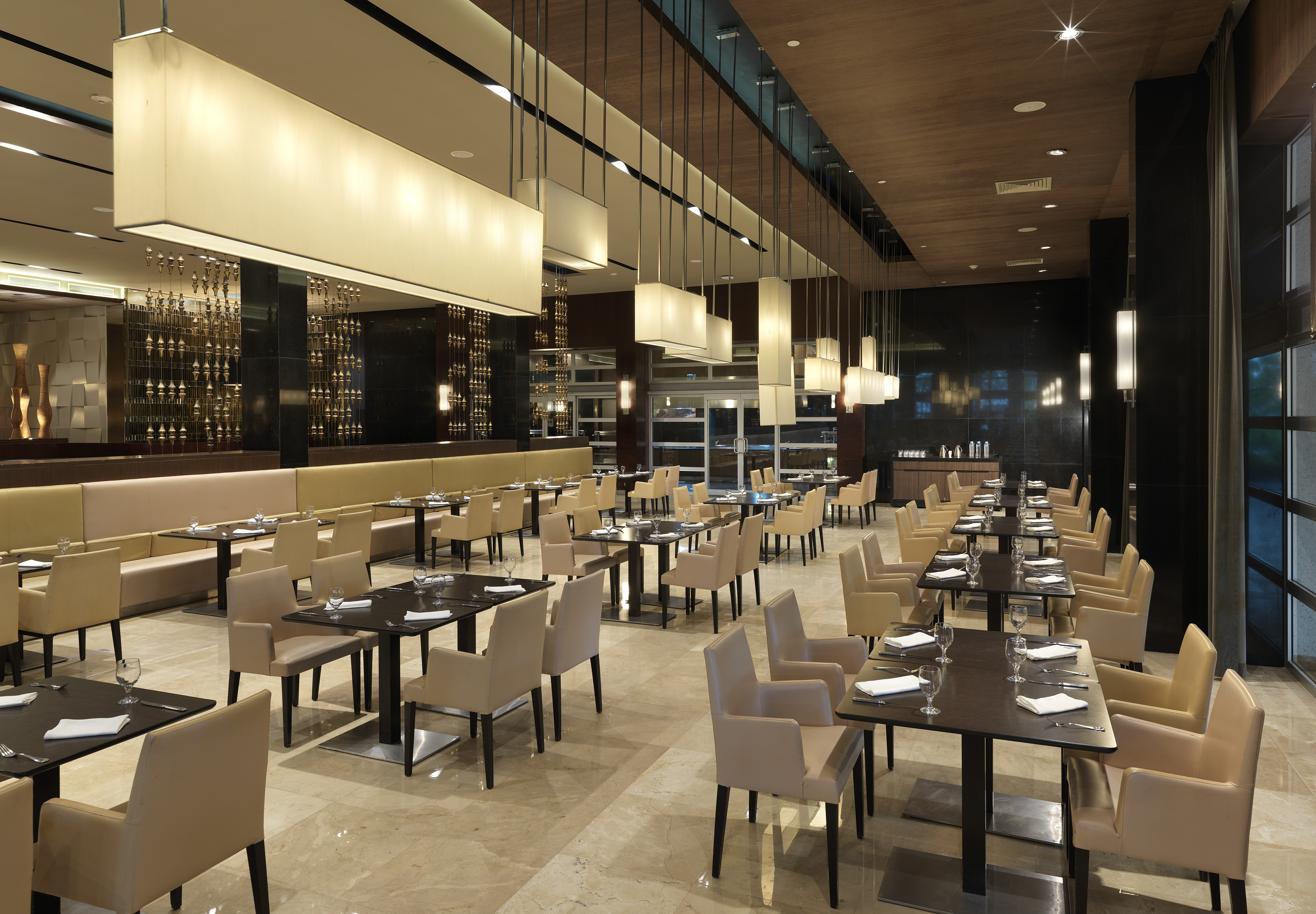 Elegant modern restaurant dining room with set tables and stylish lighting.