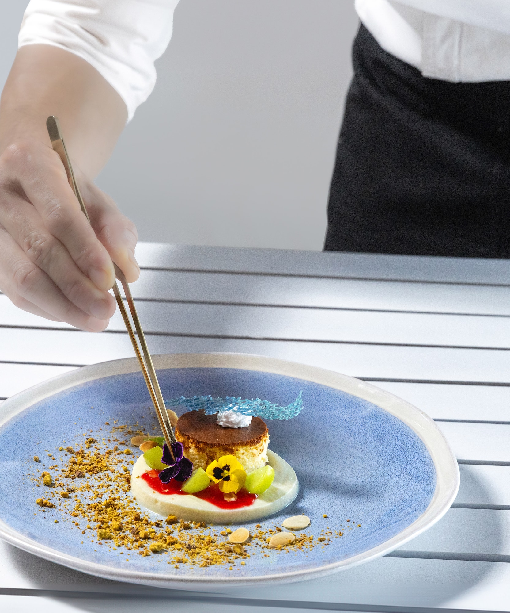 a person holding chopsticks to a plate of food