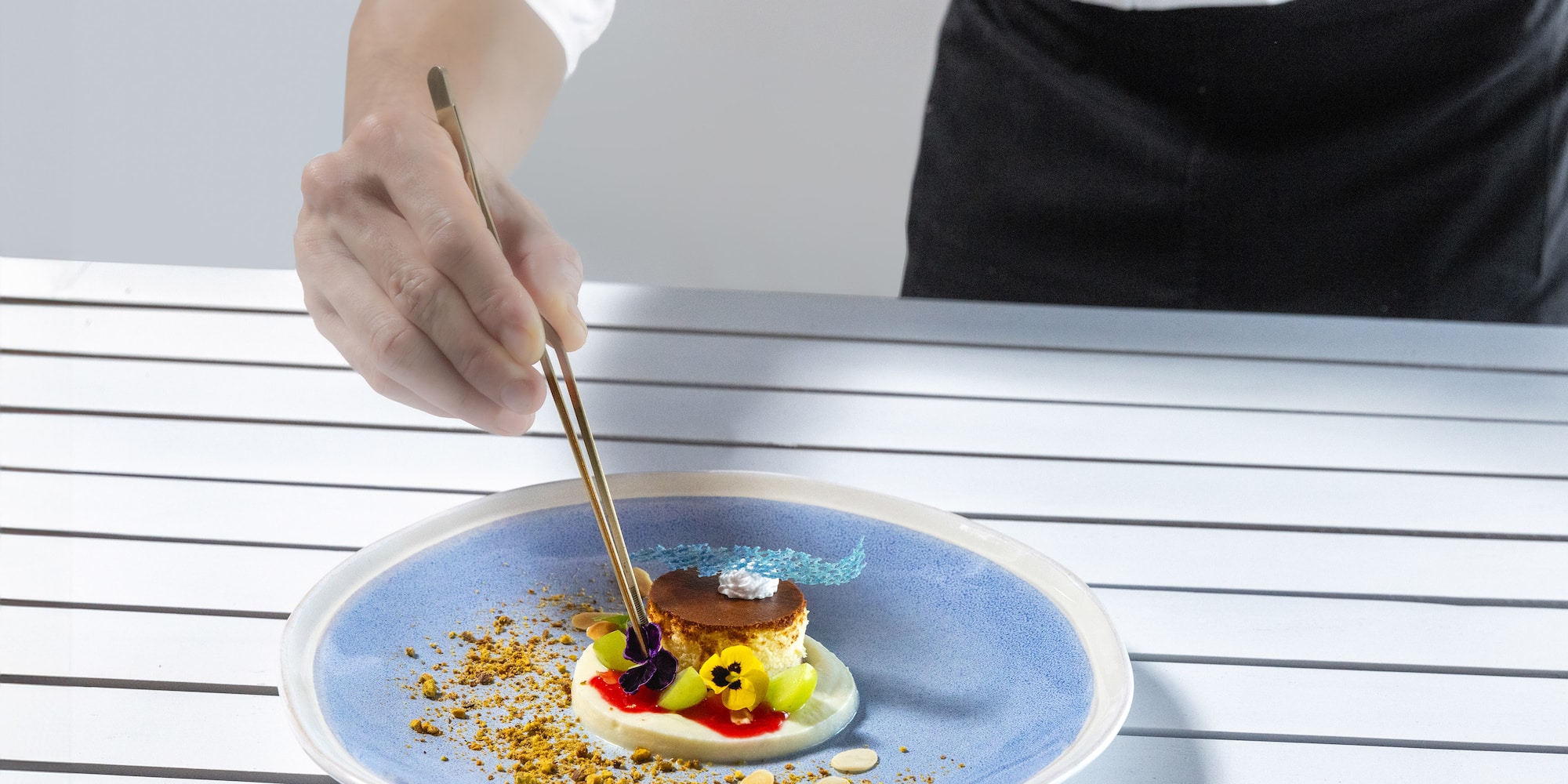 a person holding chopsticks to a plate of food