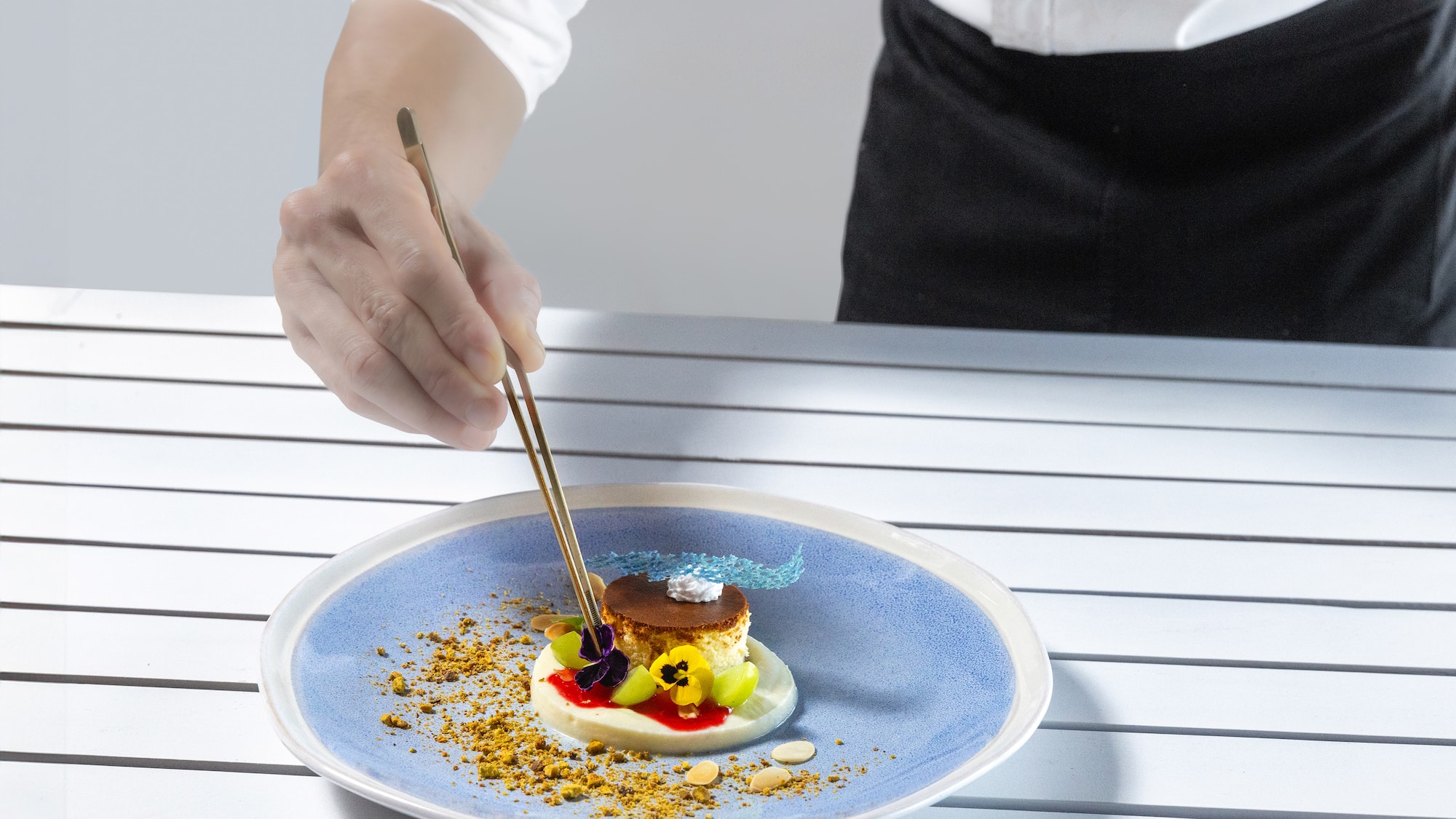 a person holding chopsticks to a plate of food