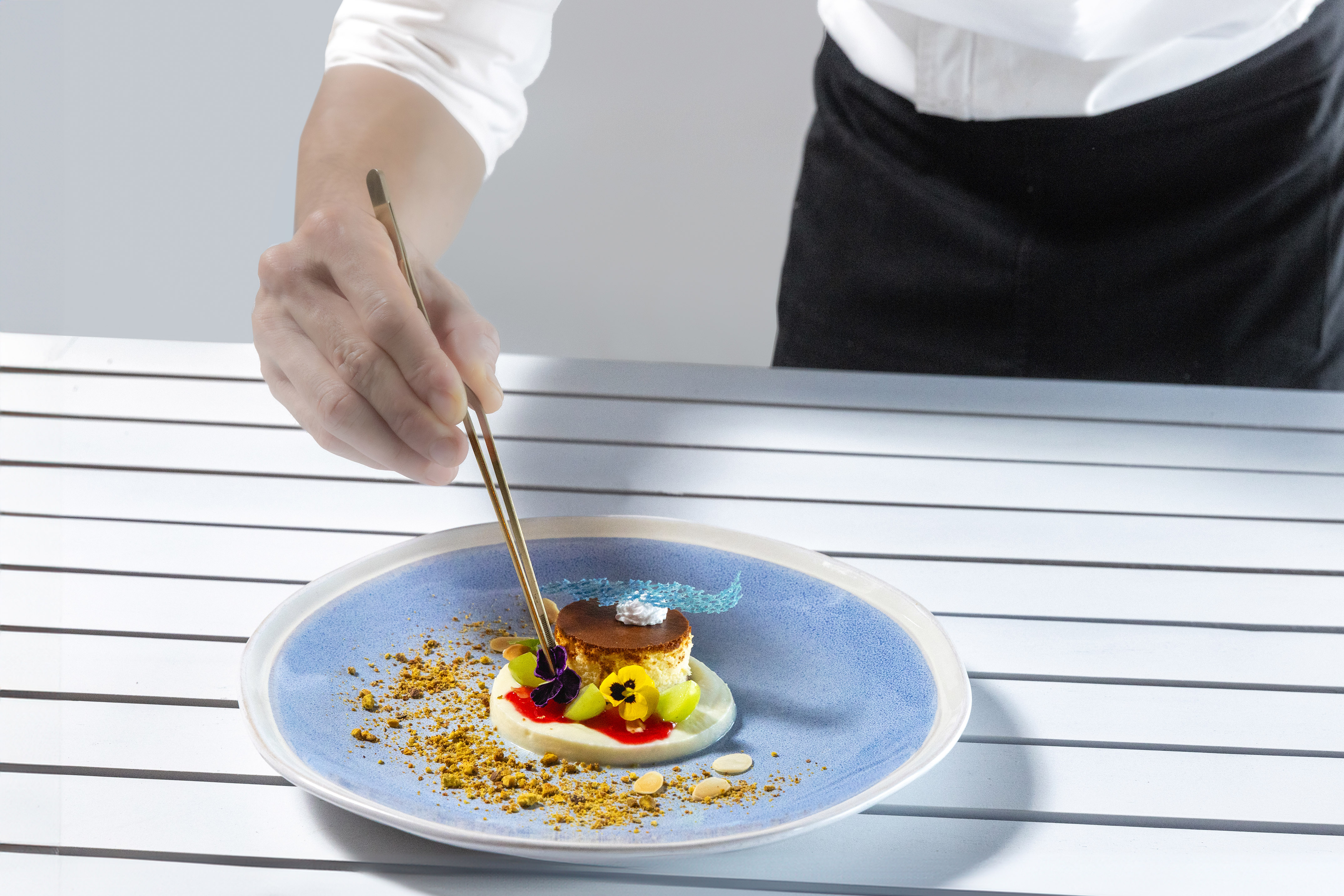a person holding chopsticks to a plate of food