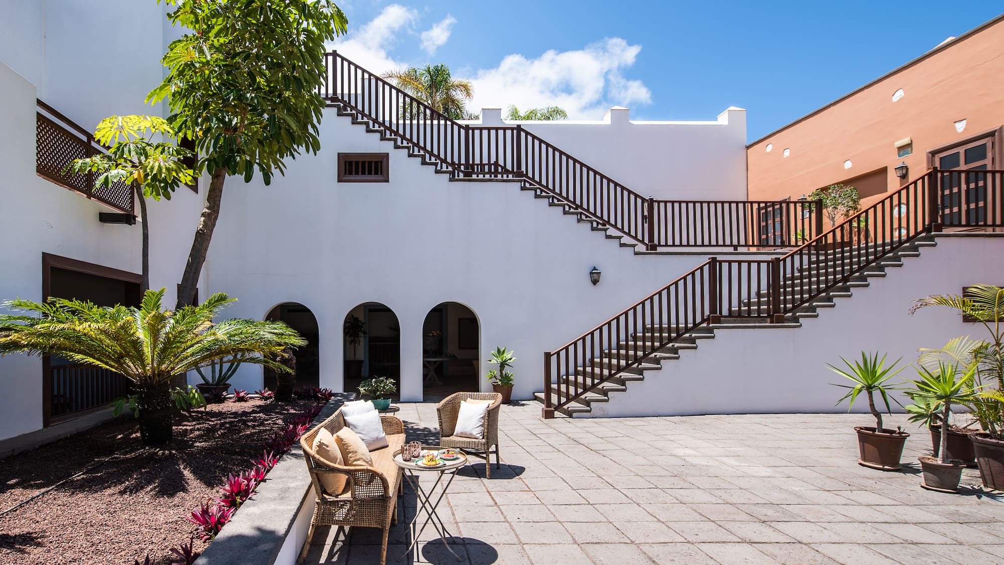 a patio with a table and chairs and a tree