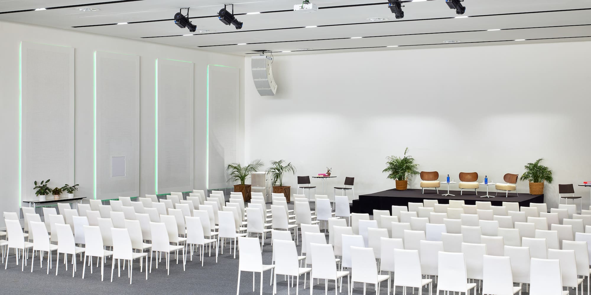 a room with white chairs and a stage