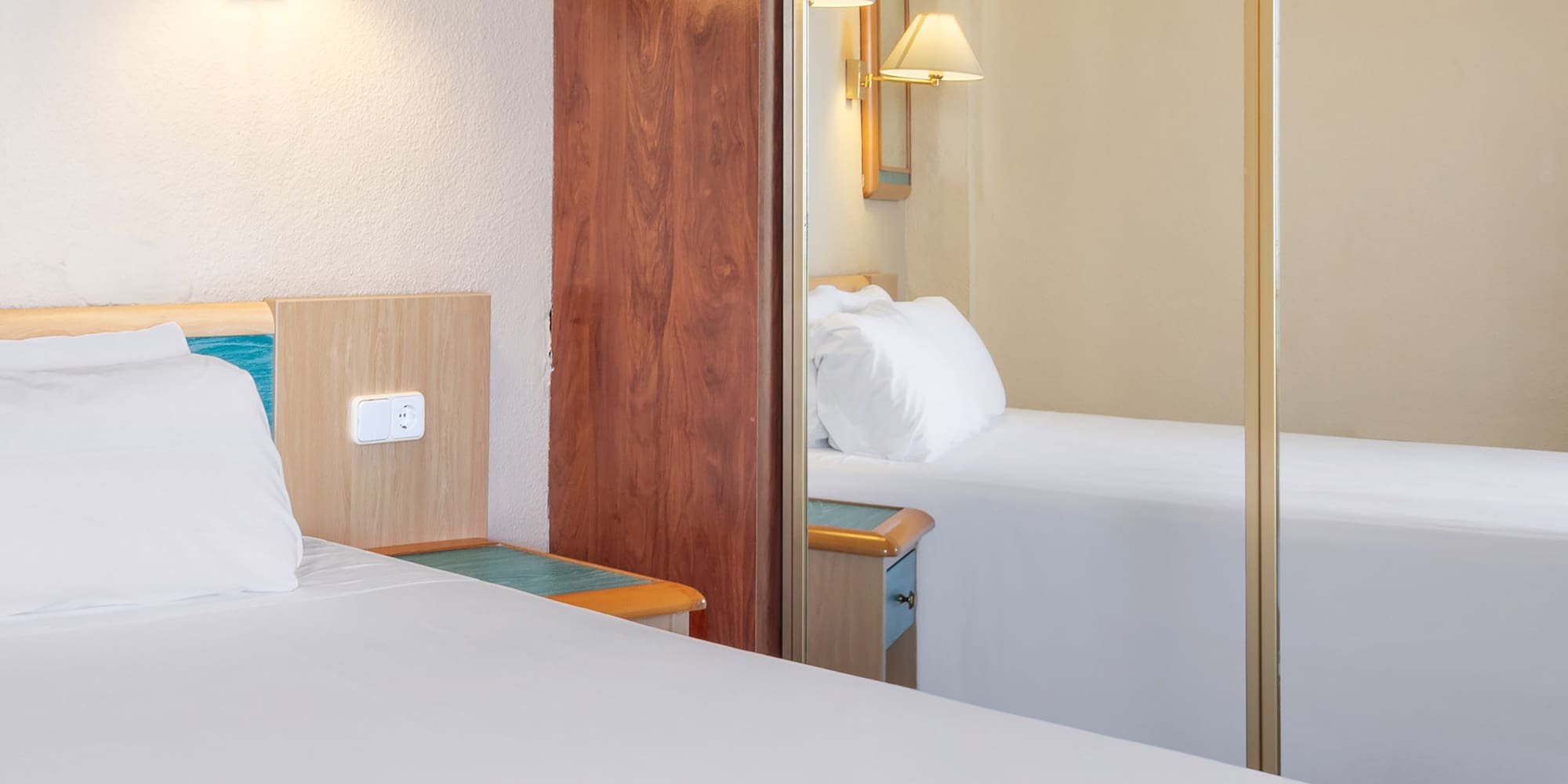 a room with a mirror and a bed