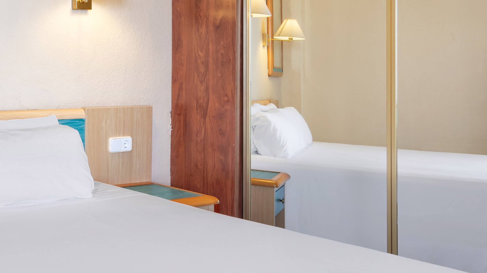 a room with a mirror and a bed