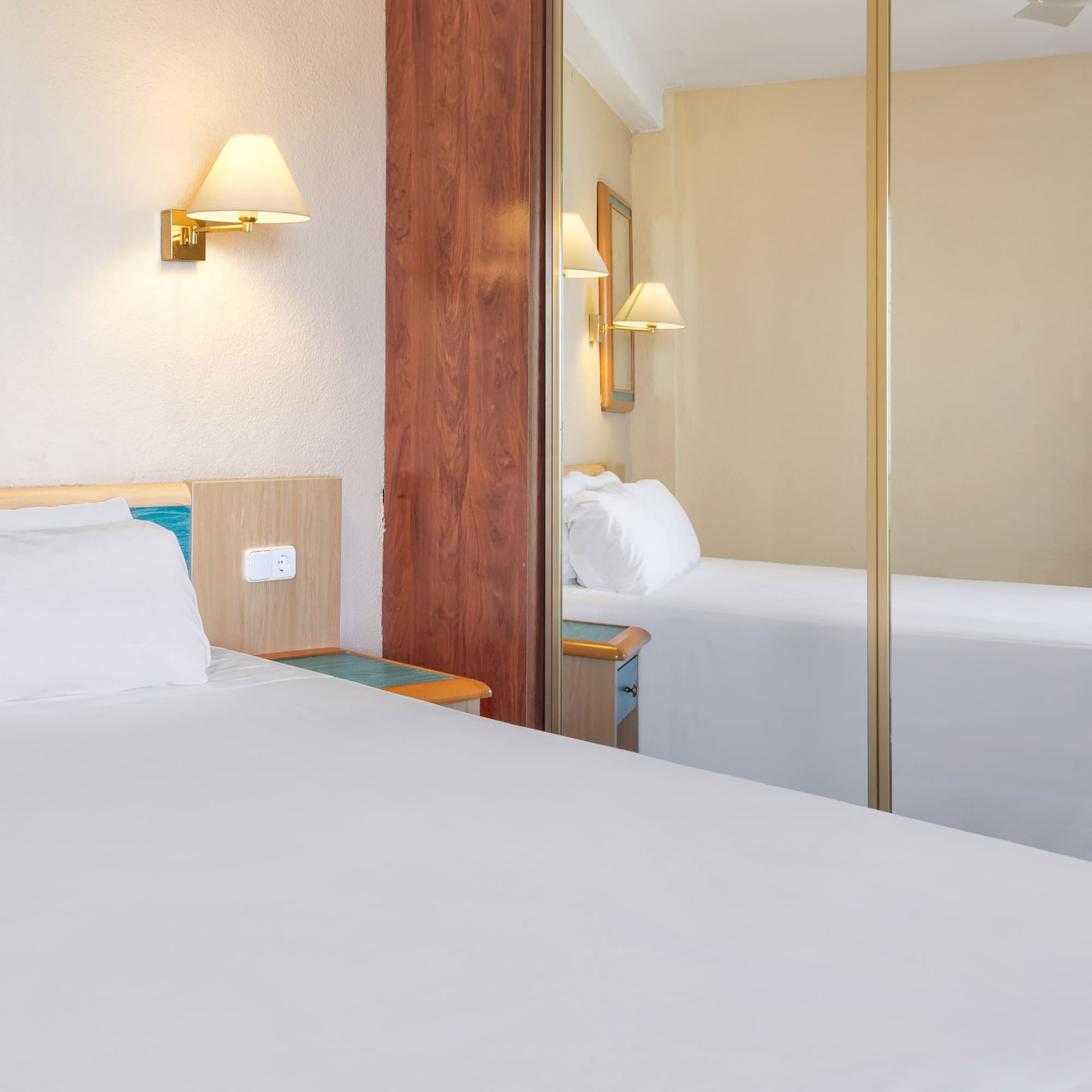 a room with a mirror and a bed