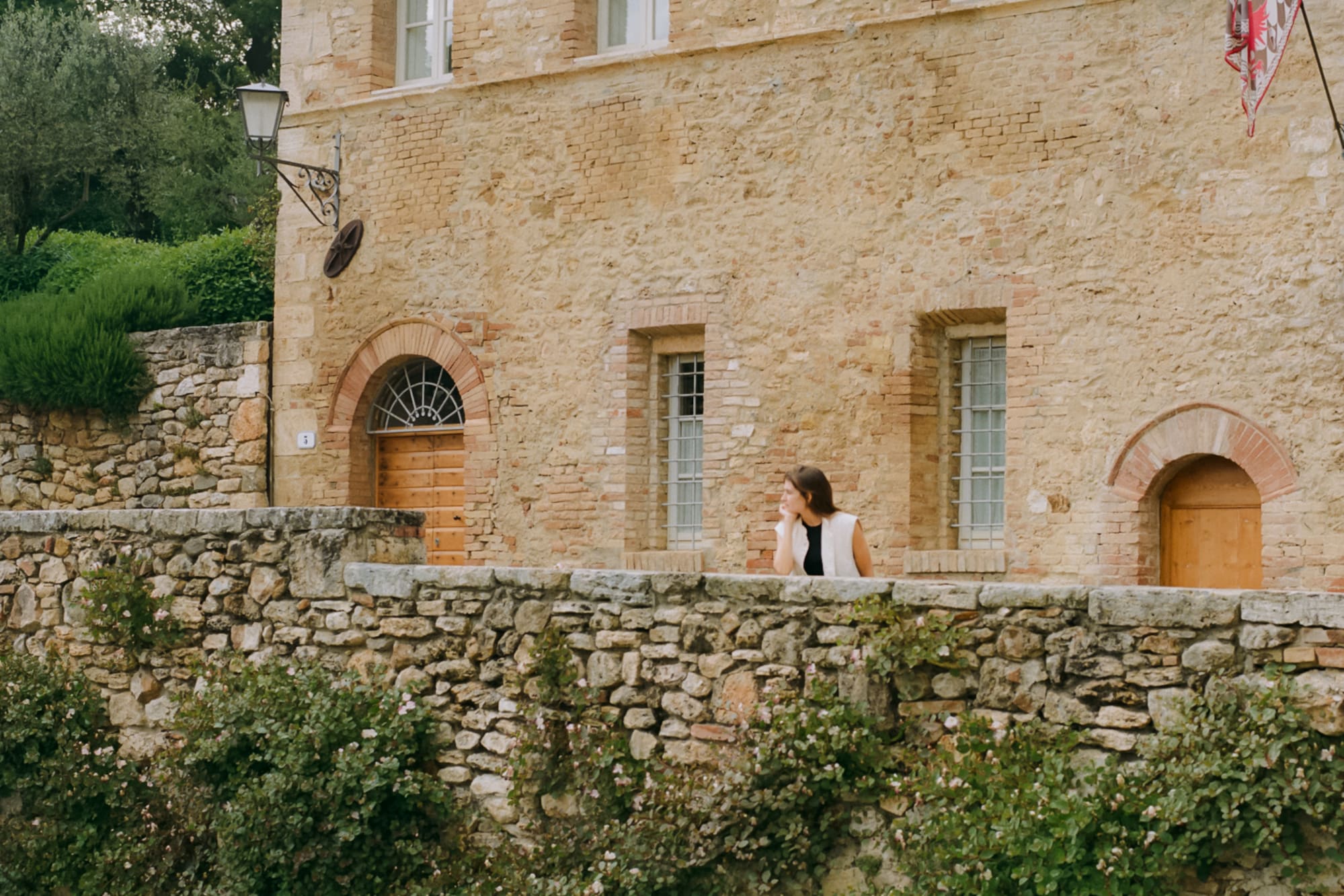 a woman standing on a stone wall next to a river
