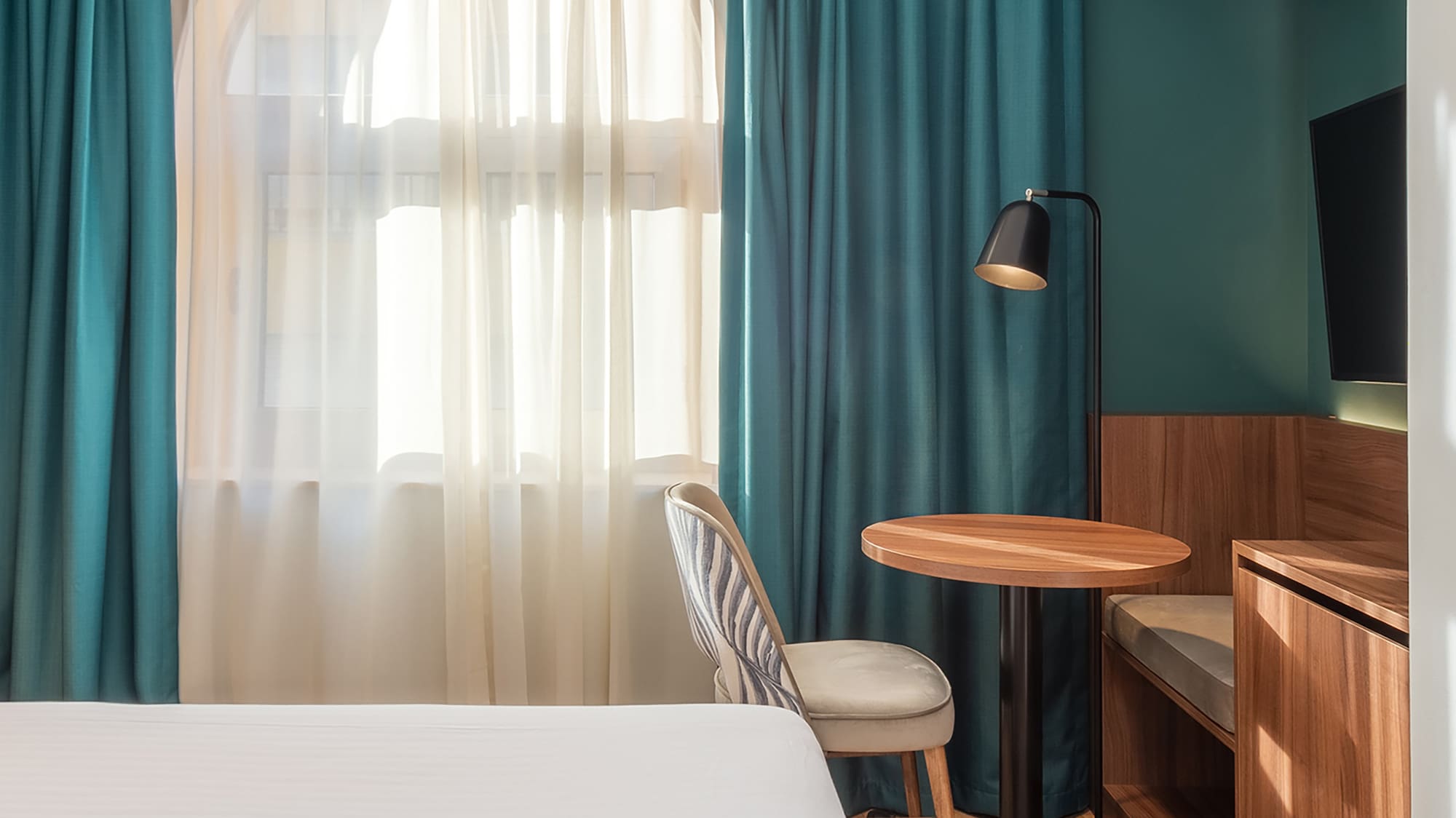 a room with a bed and a table and chair