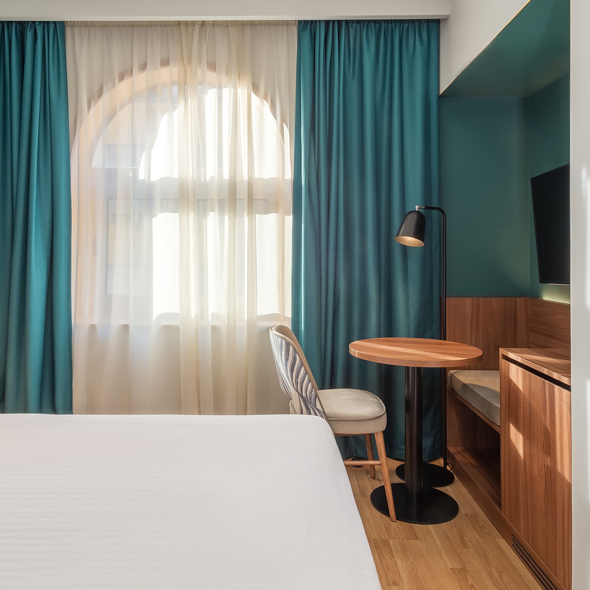 a room with a bed and a table and chair