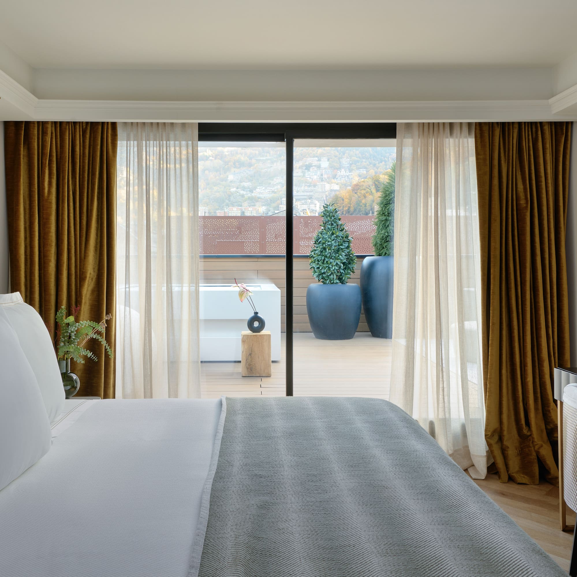 a bed with a glass door leading to a balcony