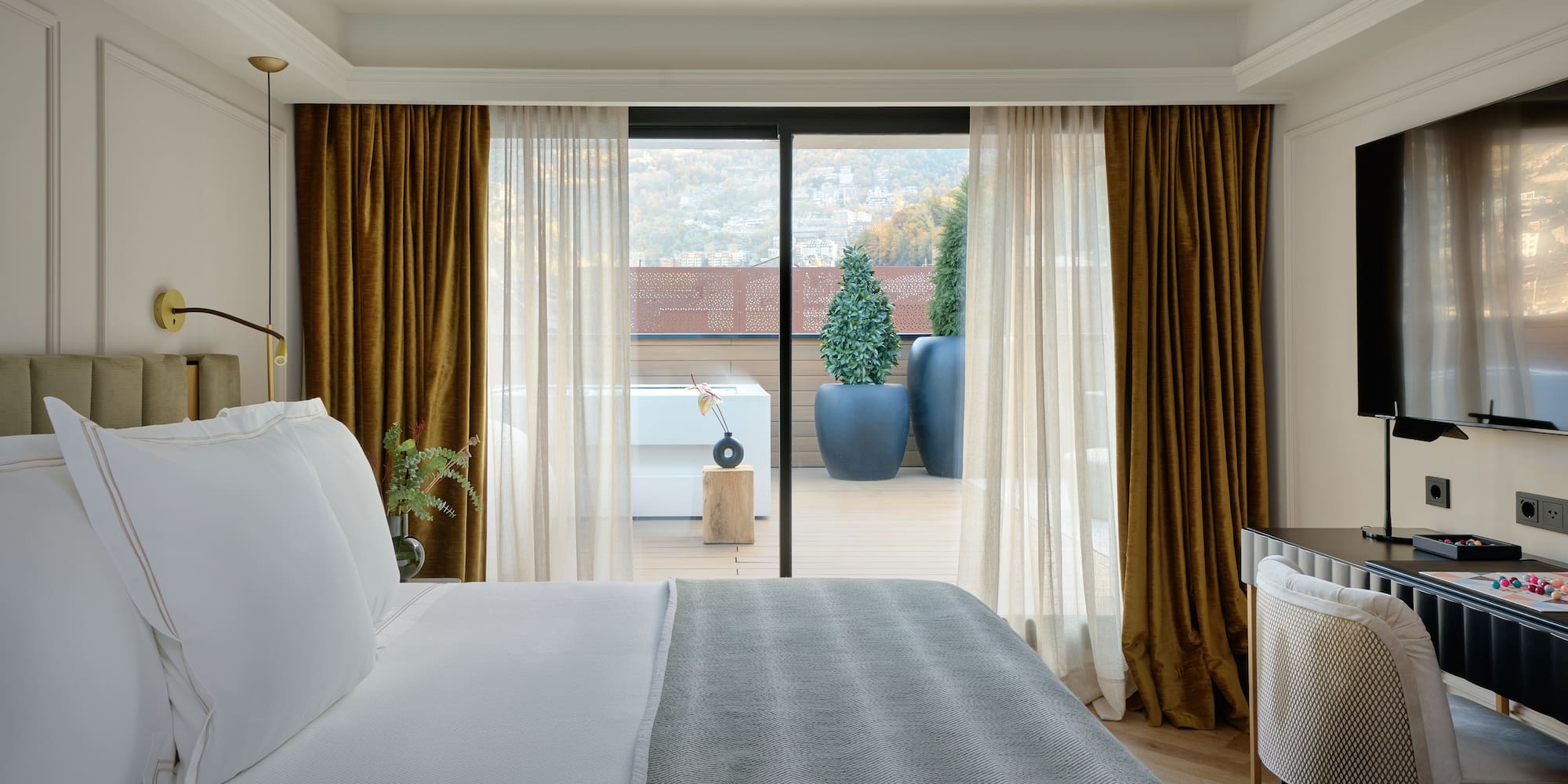 a bed with a glass door leading to a balcony