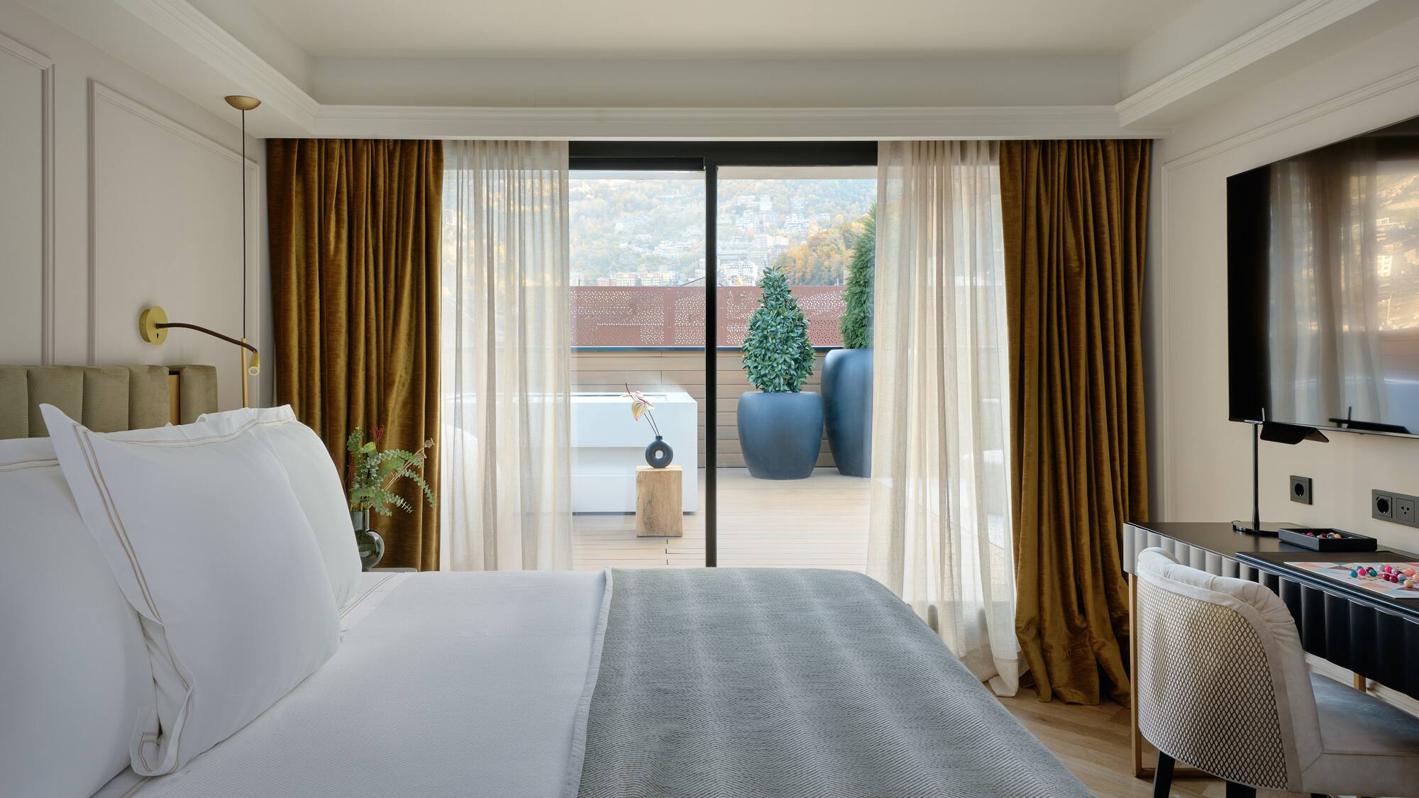a bed with a glass door leading to a balcony