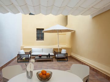 a patio with a table and chairs and an umbrella