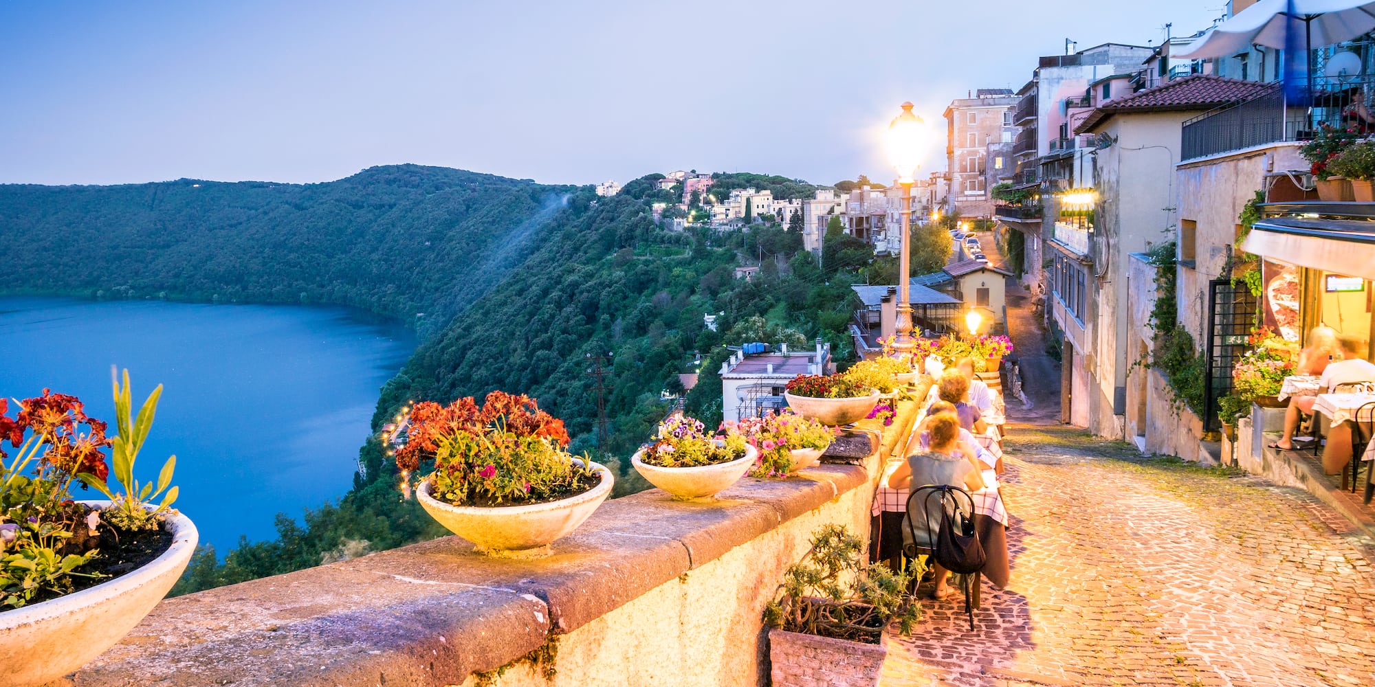 a stone path with a river and a city in the background
