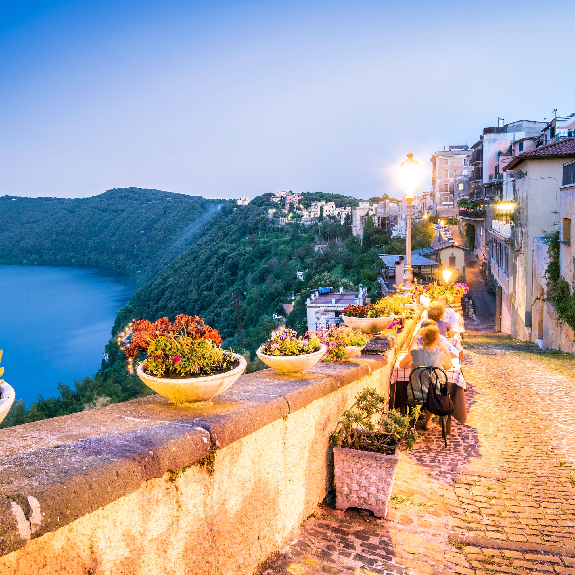 a stone path with a river and a city in the background