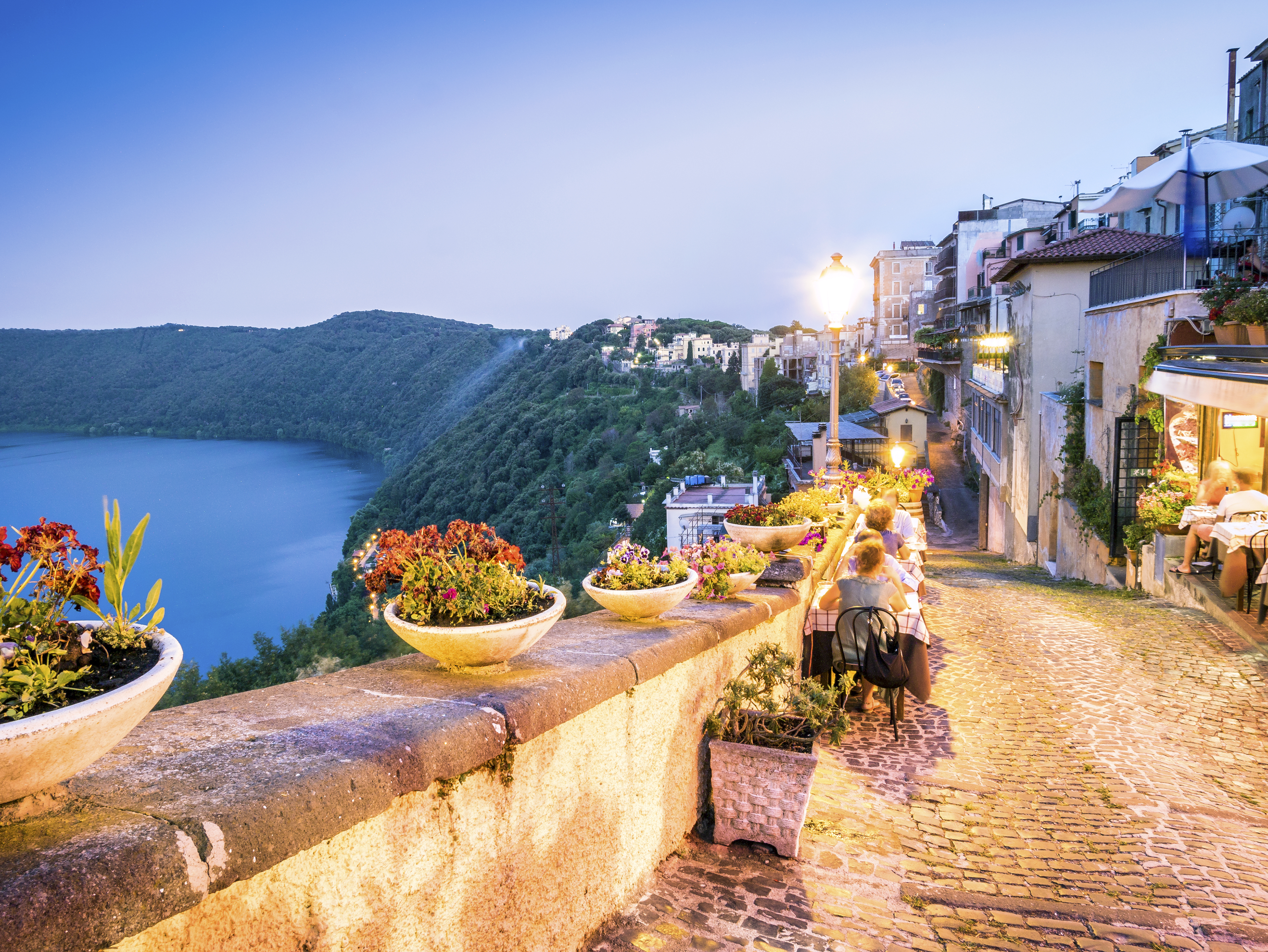 a stone path with a river and a city in the background