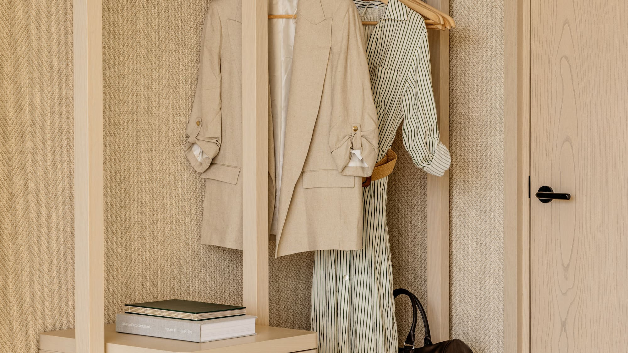 a closet with clothes on swingers and a dresser