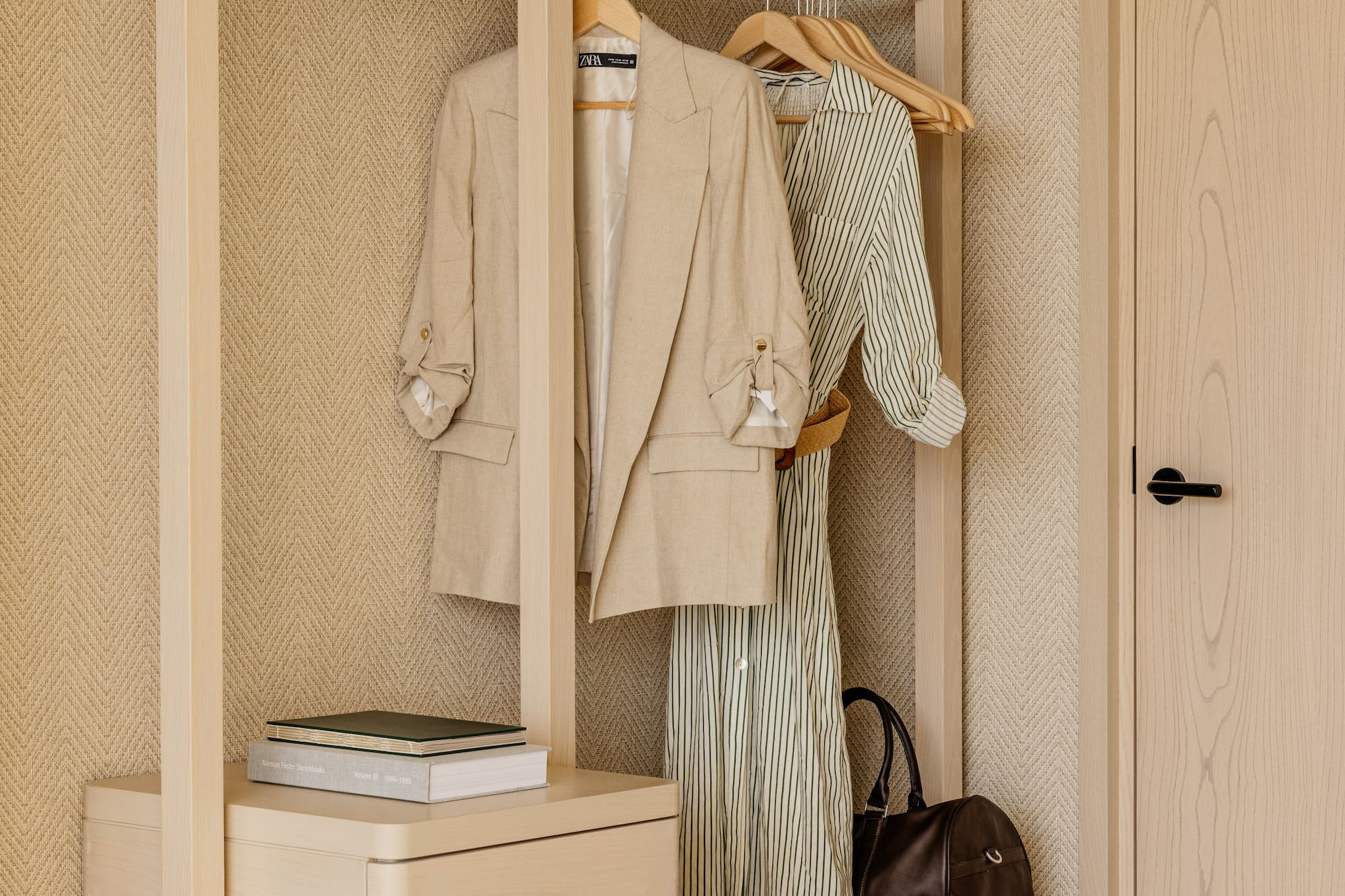 a closet with clothes on swingers and a dresser