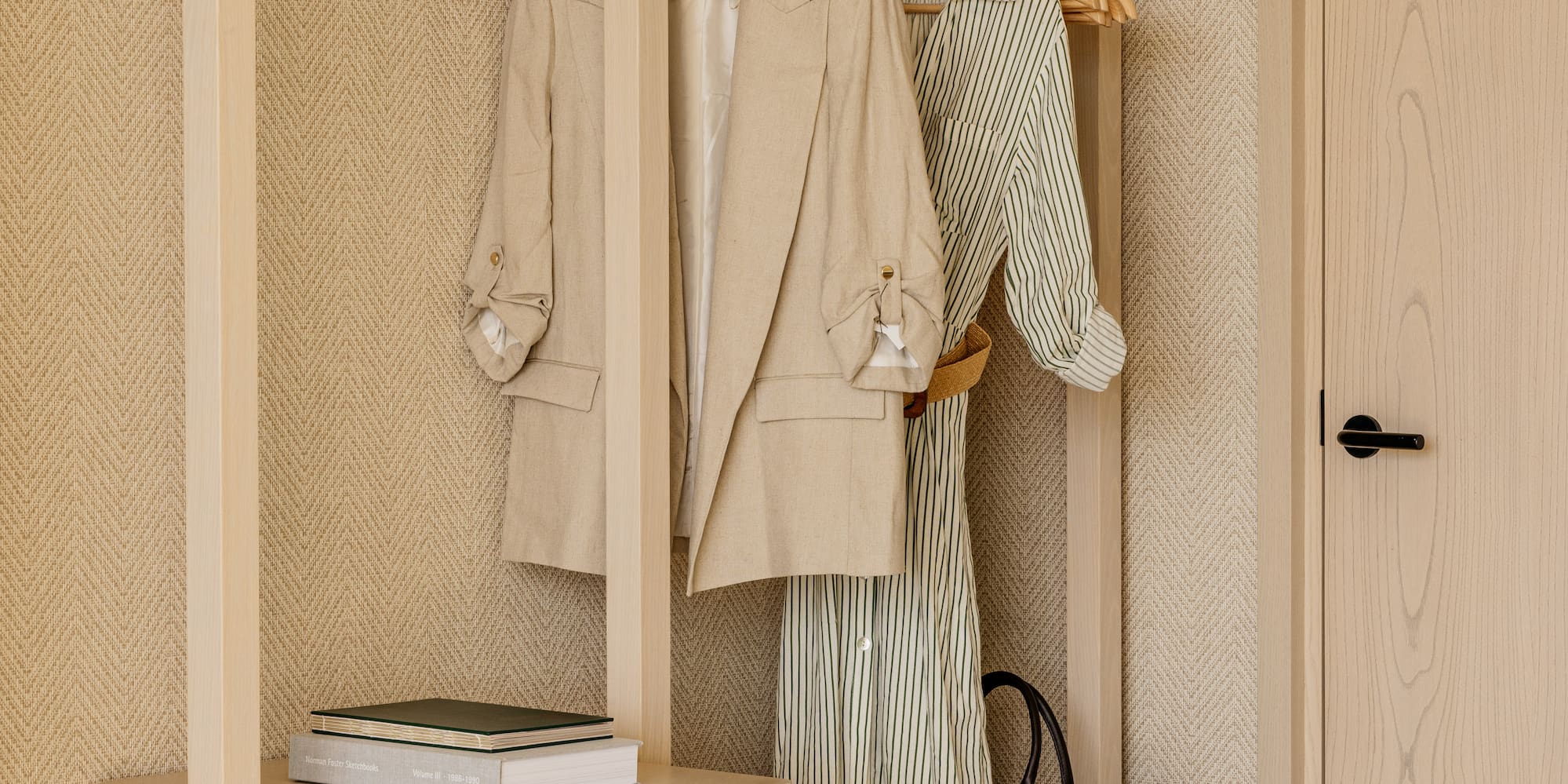 a closet with clothes on swingers and a dresser