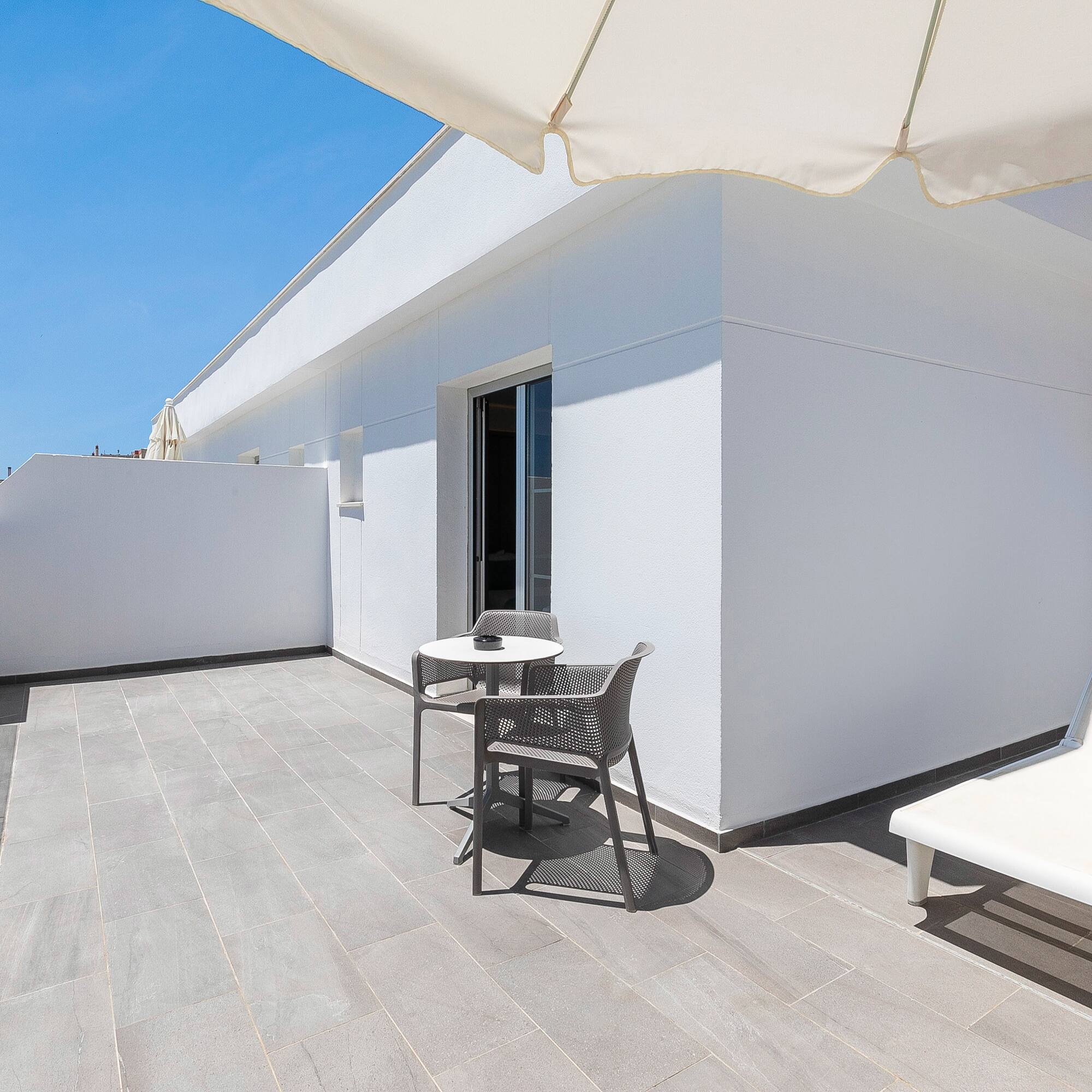 a patio with chairs and a table
